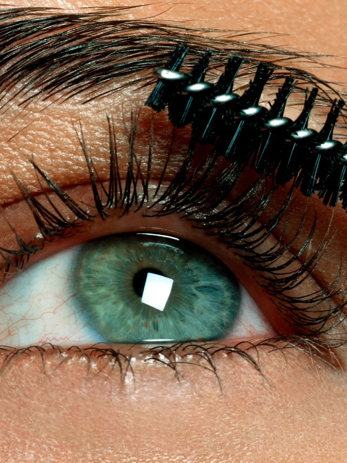 Grüne Augen werden mit brauner Mascara geschminkt.