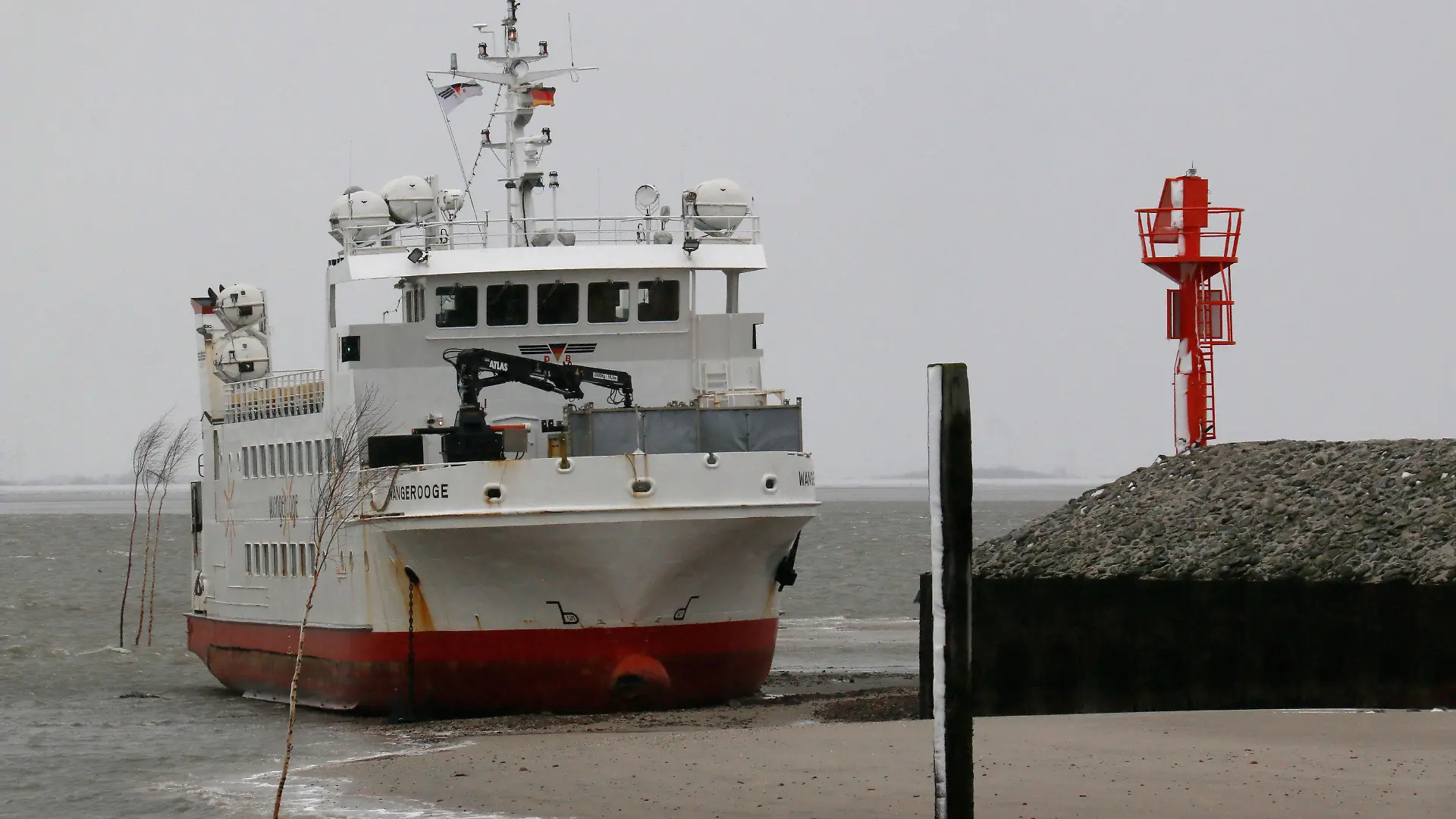 31.03.2022, Niedersachsen, Wangerooge: In der Hafeneinfahrt der Nordsee-Insel Wangerooge ist eine Fähre auf Grund gelaufen. Es gebe keine Verletzten unter den rund 100 Passagieren an Bord, sagte ein Sprecher der Deutschen Bahn, die die Fähre betreibt. Foto: Peter Kuchenbuch-Hanken/dpa +++ dpa-Bildfunk +++