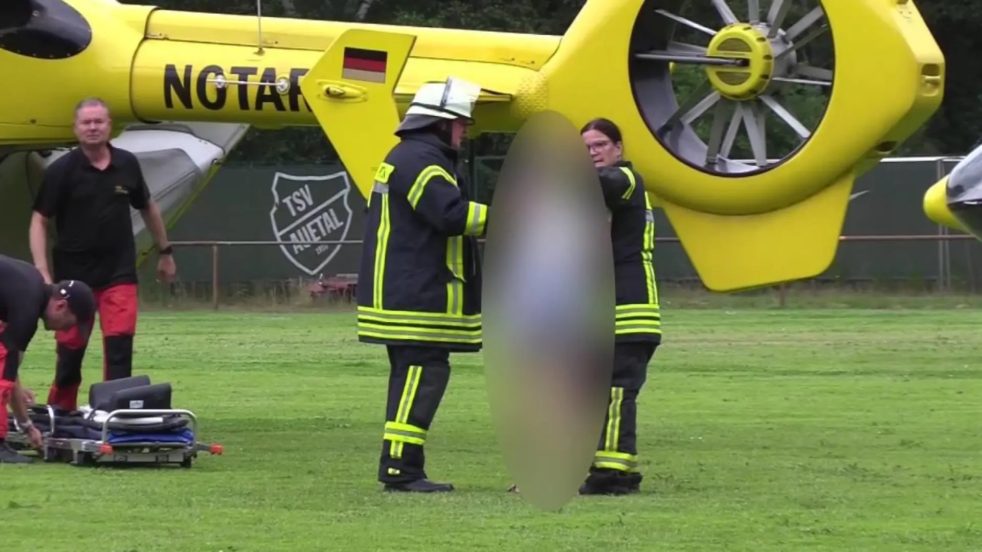 Feuerwehrleute trösten eine Person auf einem Fußballfeld nach dem tödlichen Unfall in Toppenstedt (Landkreis Harburg)