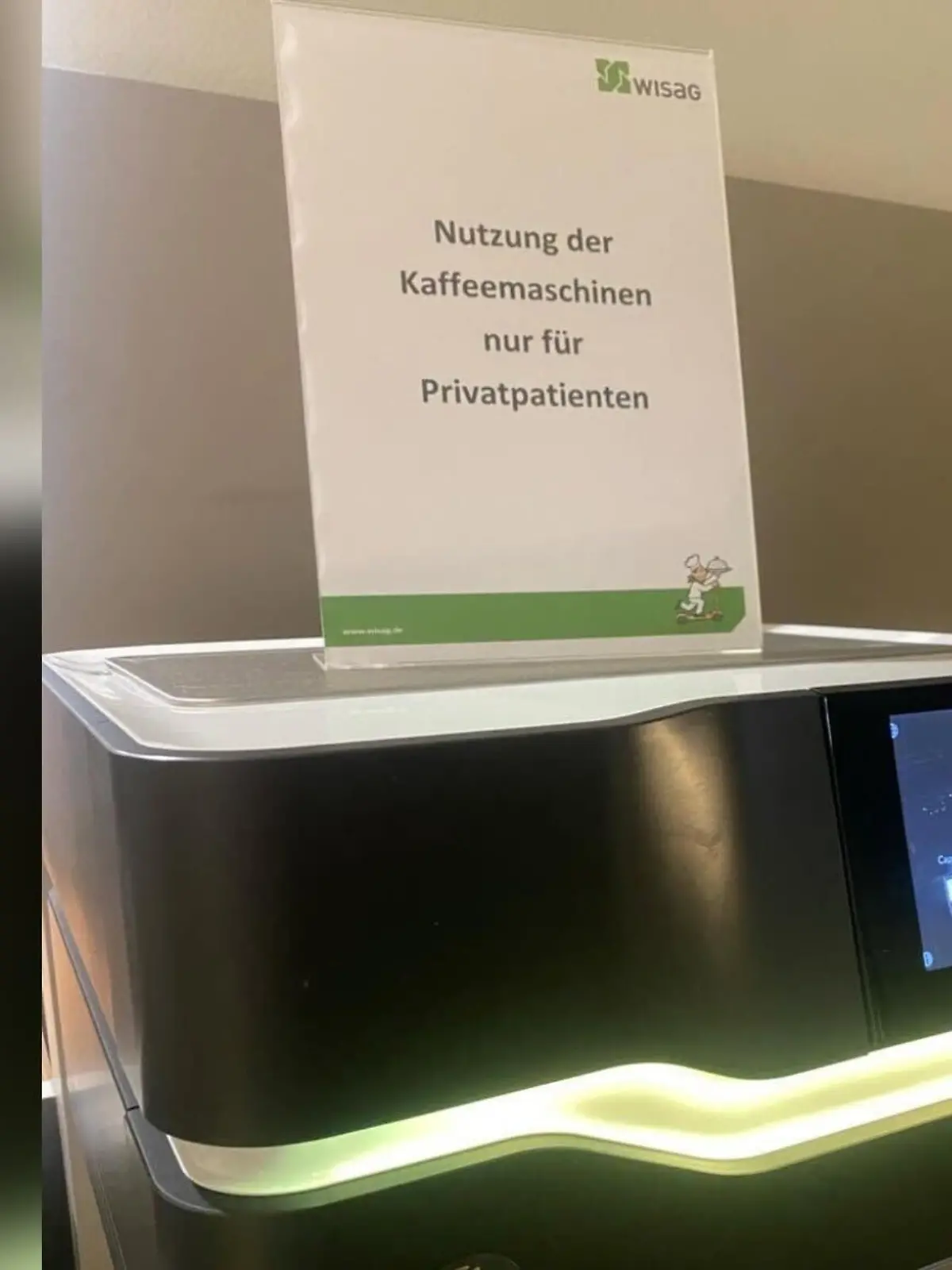 Bild einer Kaffeemaschine mit einem Hinweisschild, dass der Kaffee nur für Privatpatienten ist