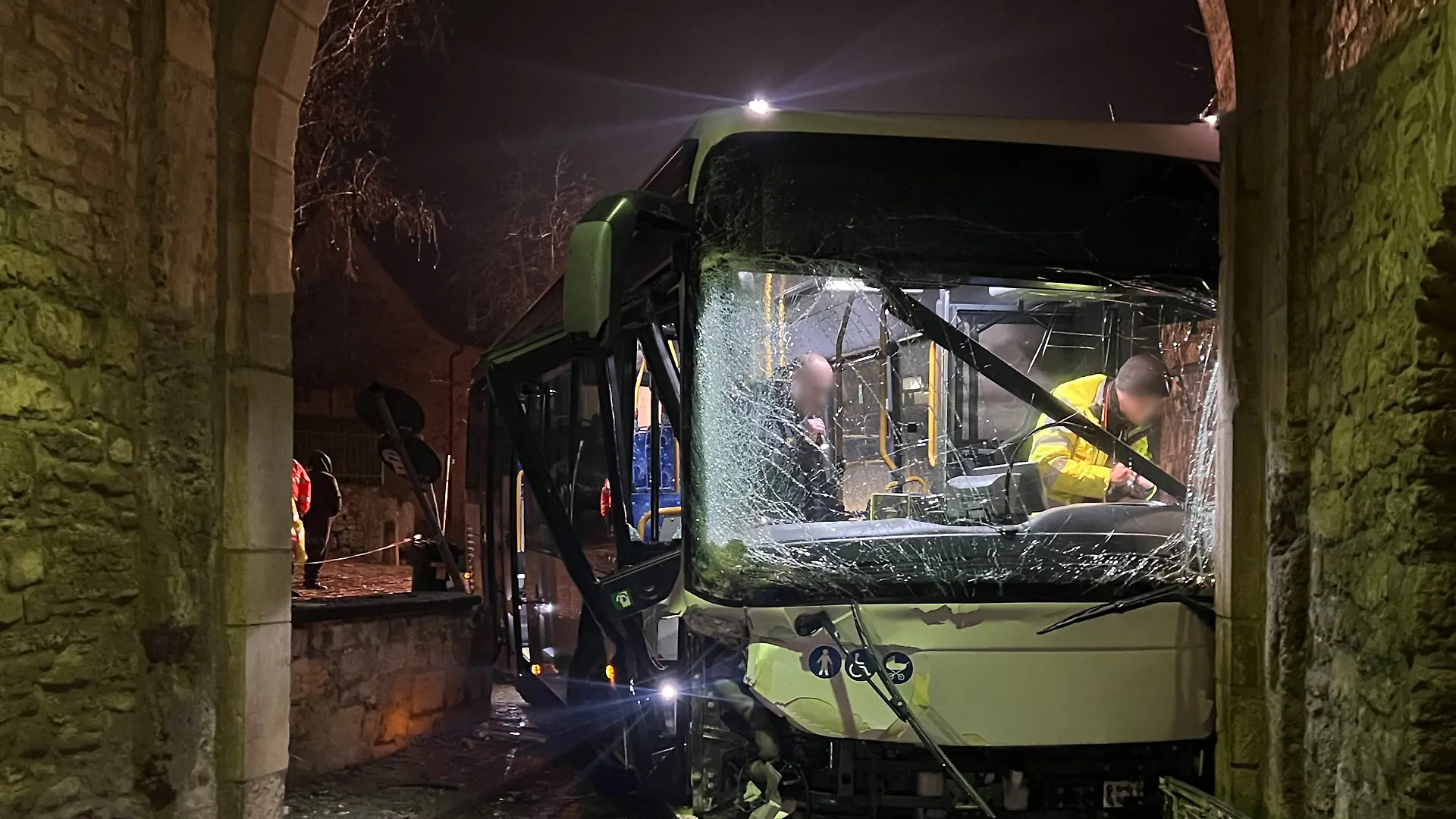 Am Mittwochmorgen steht in Sommerhausen im Landkreis Würzburg ein schwer beschädigter Bus in einem Torbogen.