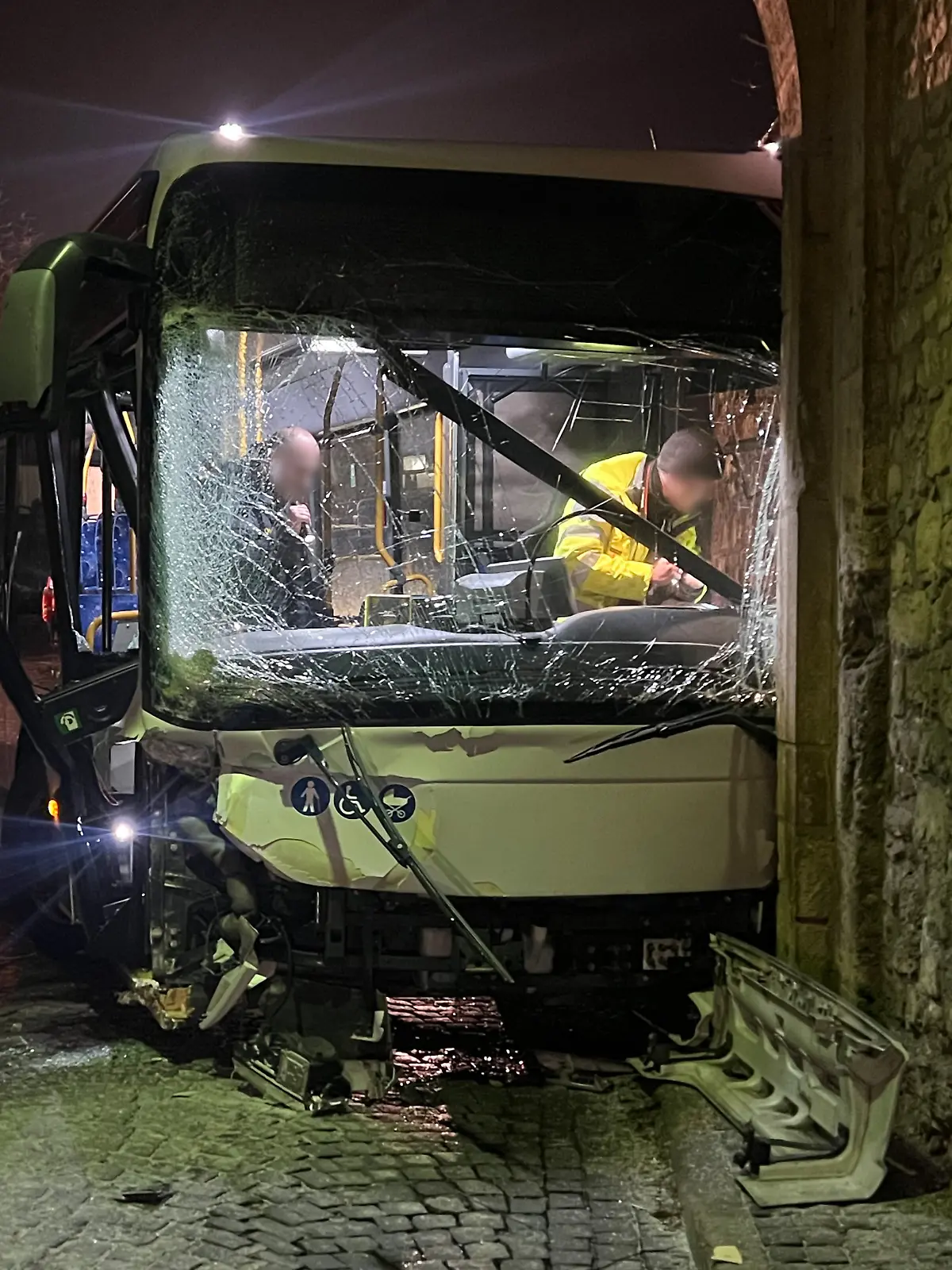 Am Mittwochmorgen steht in Sommerhausen im Landkreis Würzburg ein schwer beschädigter Bus in einem Torbogen.