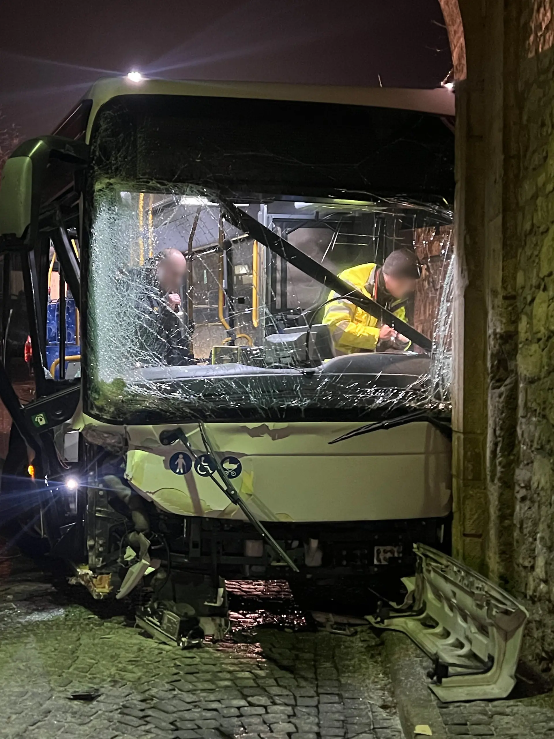 Am Mittwochmorgen steht in Sommerhausen im Landkreis Würzburg ein schwer beschädigter Bus in einem Torbogen.