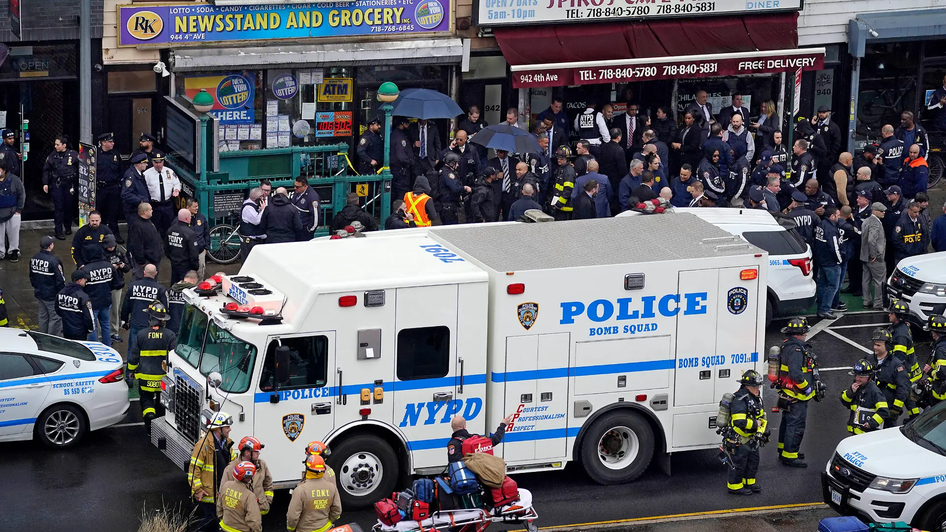 12.04.2022, USA, New York: Mitarbeiter des New York City Police Department versammeln sich am Eingang einer U-Bahn-Station im New Yorker Stadtteil Brooklyn. Bei Schüssen in einer New Yorker U-Bahn-Station sind mehrere Menschen verletzt worden. Foto: John Minchillo/AP/dpa +++ dpa-Bildfunk +++