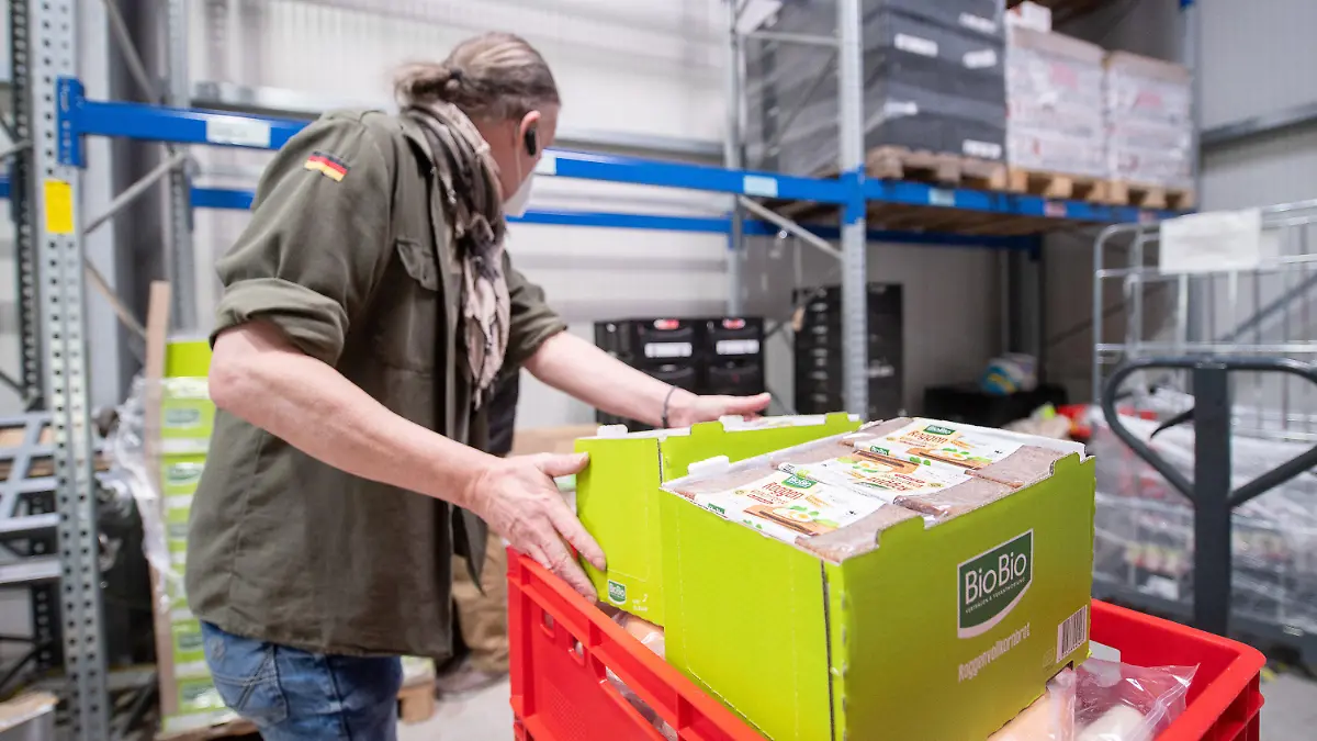 12.04.2022, Hessen, Frankfurt/Main: Ein Fahrer packt im Lager der Tafel Frankfurt Brot in eine Kiste. Die Tafel in Frankfurt hat momentan damit zu kämpfen, dass sie weniger Spenden bei einer höheren Nachfrage bekommt. Foto: Sebastian Gollnow/dpa +++ dpa-Bildfunk +++