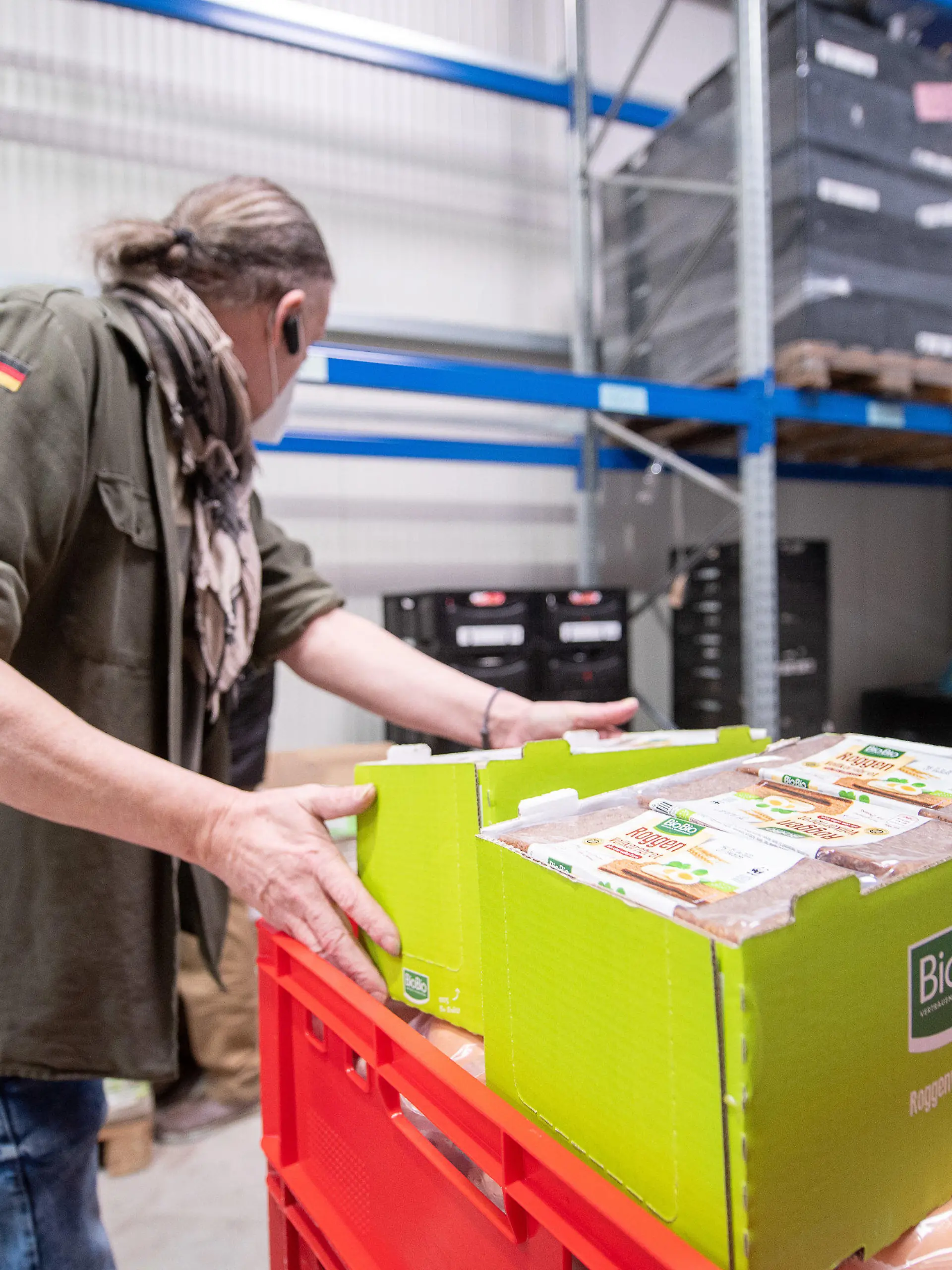 12.04.2022, Hessen, Frankfurt/Main: Ein Fahrer packt im Lager der Tafel Frankfurt Brot in eine Kiste. Die Tafel in Frankfurt hat momentan damit zu kämpfen, dass sie weniger Spenden bei einer höheren Nachfrage bekommt. Foto: Sebastian Gollnow/dpa +++ dpa-Bildfunk +++