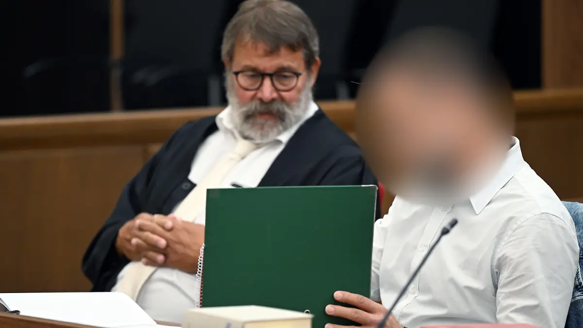 07.07.2023, Nordrhein-Westfalen, Wuppertal: Der Angeklagte (r) sitzt neben seinem Anwalt Jochen Ohliger im Gerichtssaal. Ein 46-Jähriger muss sich wegen Körperverletzung mit Todesfolge vor dem Wuppertaler Landgericht verantworten. Er soll einem 32 Jahre alten Mann Silikonöl in Penis und Hodensack gespritzt haben. Das Opfer wollte so seinen Penis vergrößern lassen. Foto: Federico Gambarini/dpa - ACHTUNG: Person wurde aus rechtlichen Gründen gepixelt +++ dpa-Bildfunk +++