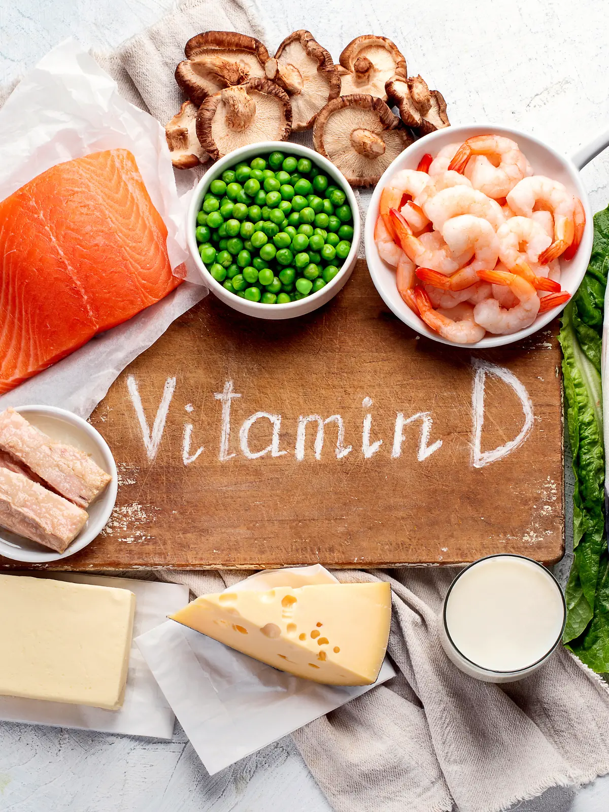 Holzbrett mit der Aufschrift Vitamin D und drum herum verschiedene Lebensmittel