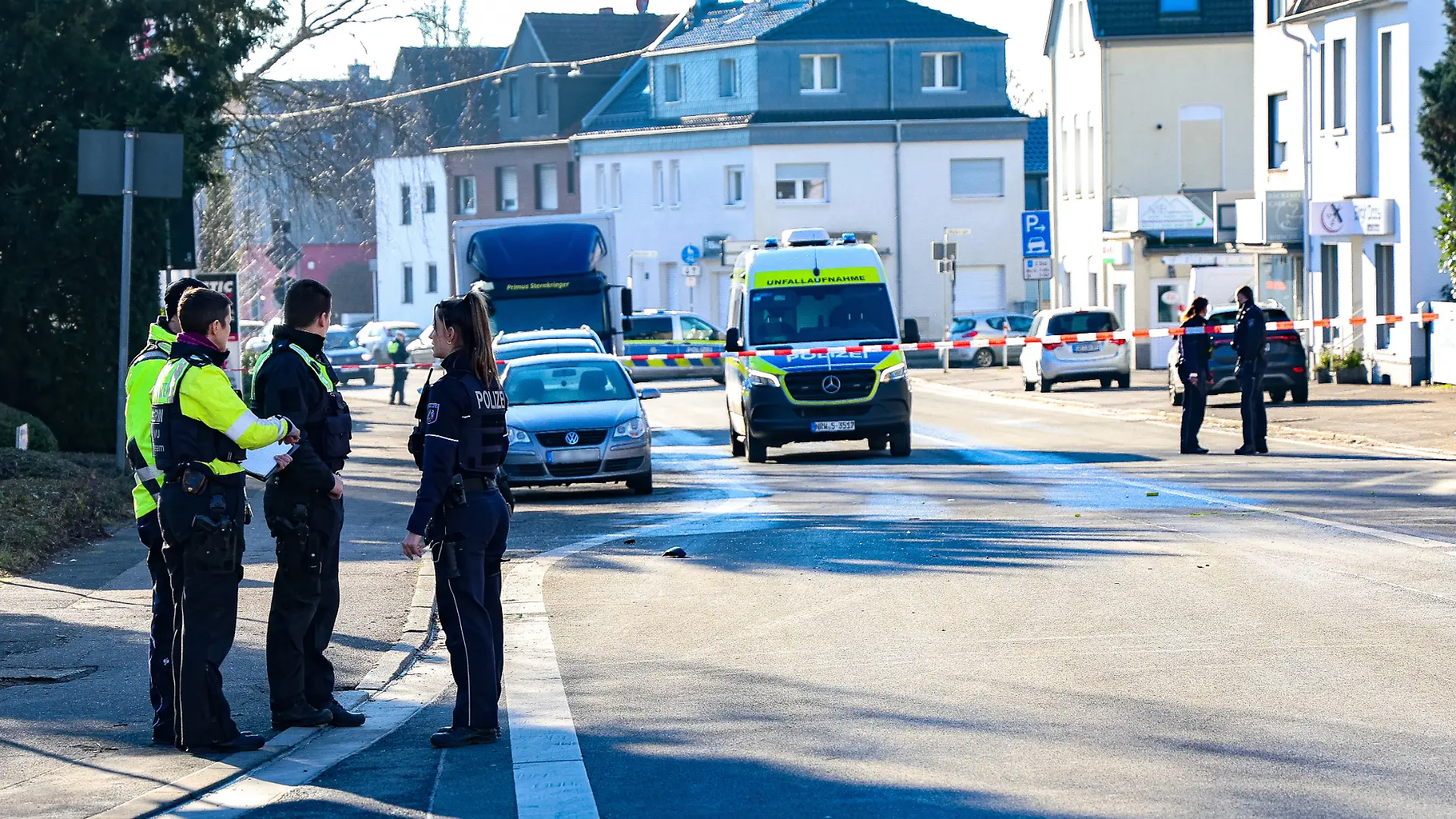 Polizeibeamte stehen an der abgesperrten Unfallstelle.