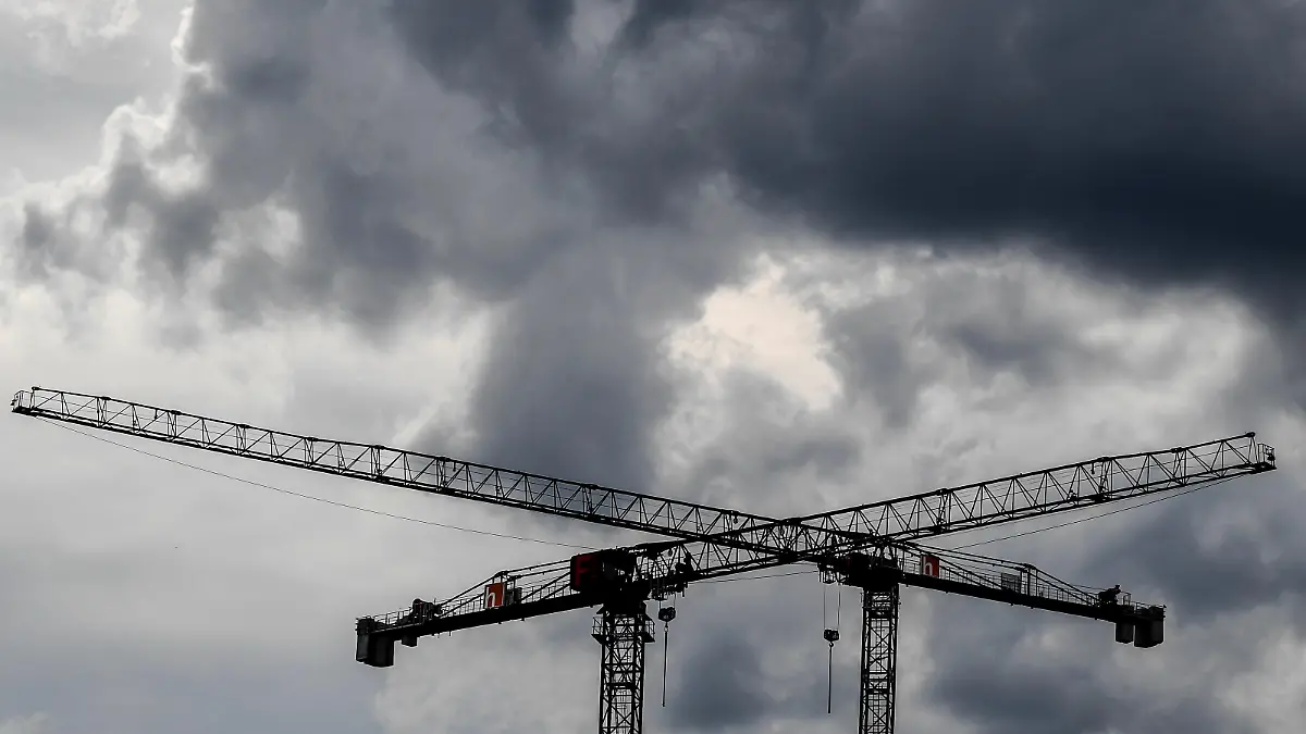 Baukräne vor dunklen Wolken.