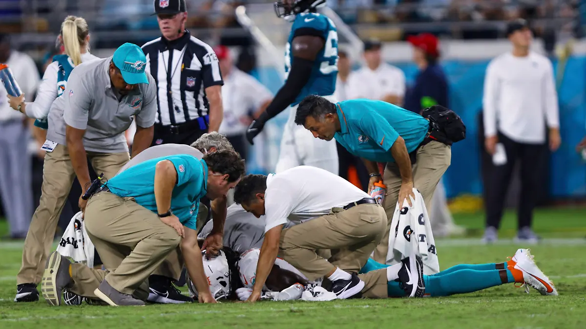 26.08.2023, USA, Jacksonville: American Football: Profiliga NFL, Vorsaison, Jacksonville Jaguars - Miami Dolphins. Wide Receiver Daewood Davis von den Miami Dolphins wird während der zweiten Hälfte des Vorbereitungsspiels untersucht. In der NFL ist knapp zwei Wochen vor dem Saisonstart erneut ein Testspiel nach der Verletzung eines Football-Profis abgebrochen worden. Daewood Davis von den Miami Dolphins blieb nach einem harten Zusammenprall in der Partie gegen die Jacksonville Jaguars am Samstag (Ortszeit) minutenlang mit dem Gesicht auf dem Boden liegen. Foto: Gary McCullough/AP/dpa +++ dpa-Bildfunk +++