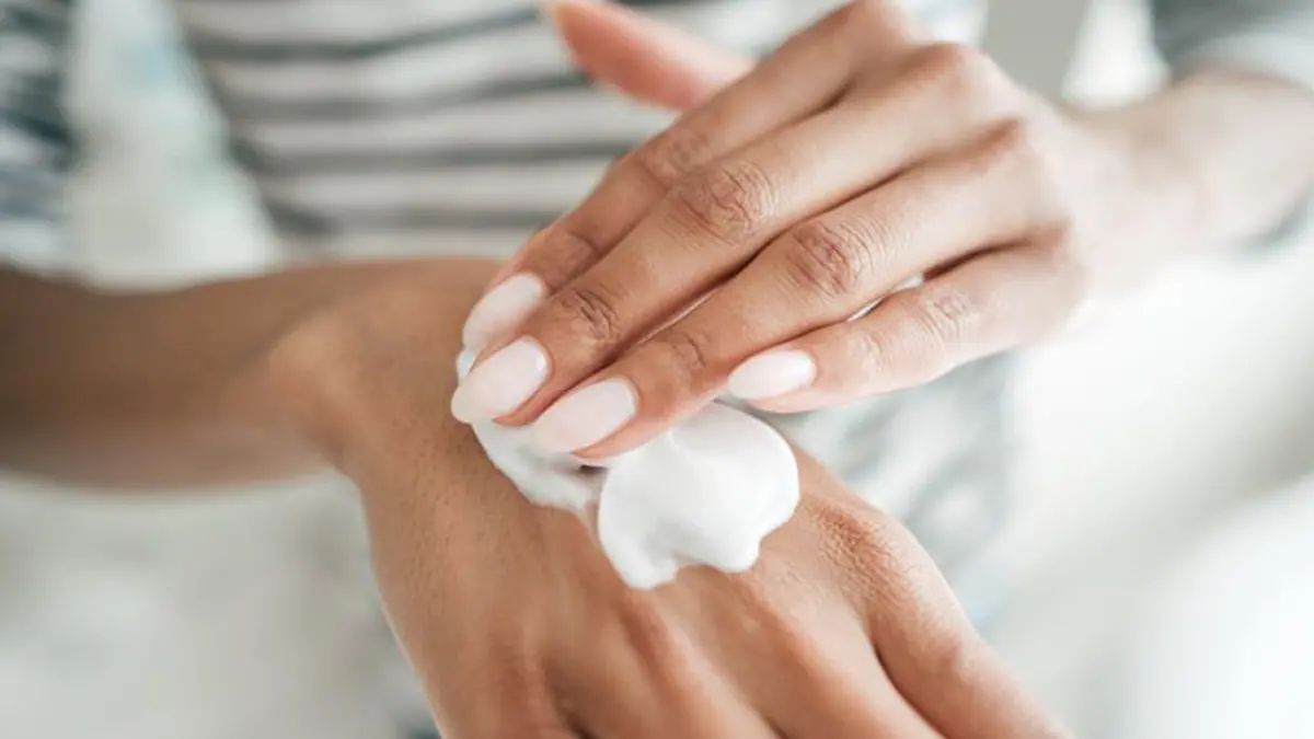 Frau cremt sich mit Handcreme ein, die nicht schmiert.