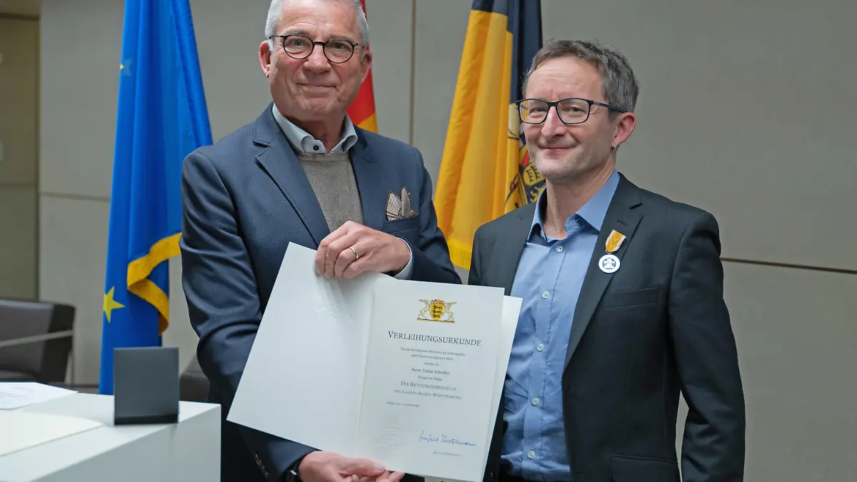 Innenminister Thomas Strobl (l.) verleiht Tobias Schneller (r.) Rettungsmedaille.