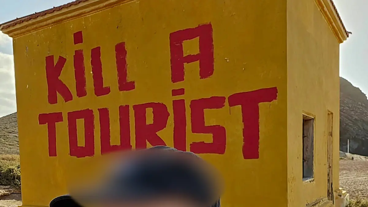 Ein Tourist macht vor dem Geschmacklos-Graffiti ein Selfie.