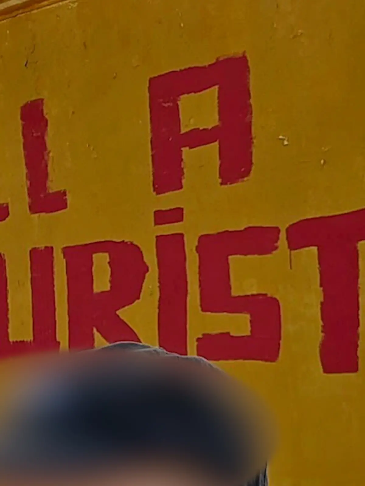 Ein Tourist macht vor dem Geschmacklos-Graffiti ein Selfie.