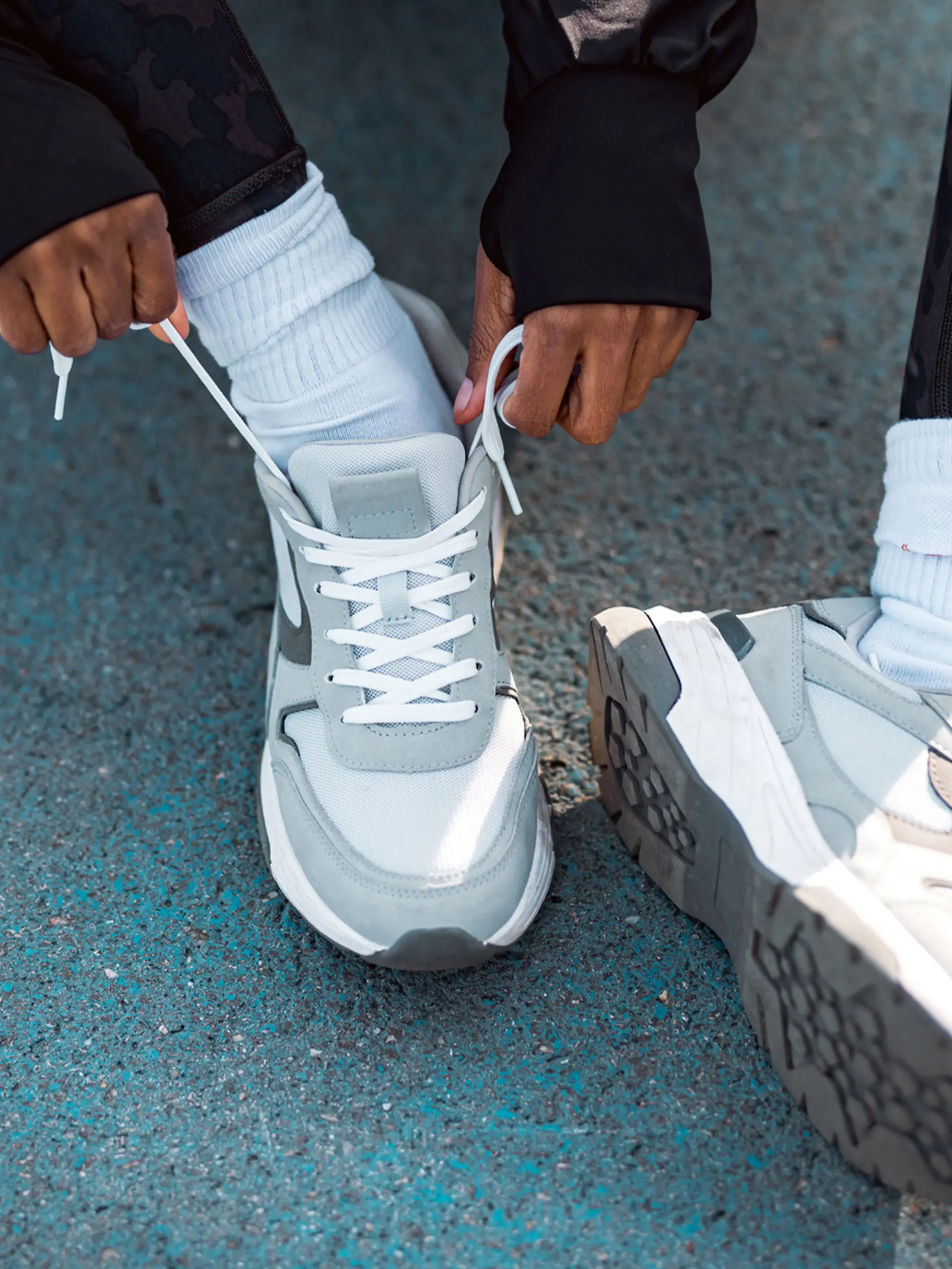 Frau trägt grauen Sneaker-Trend 2025.