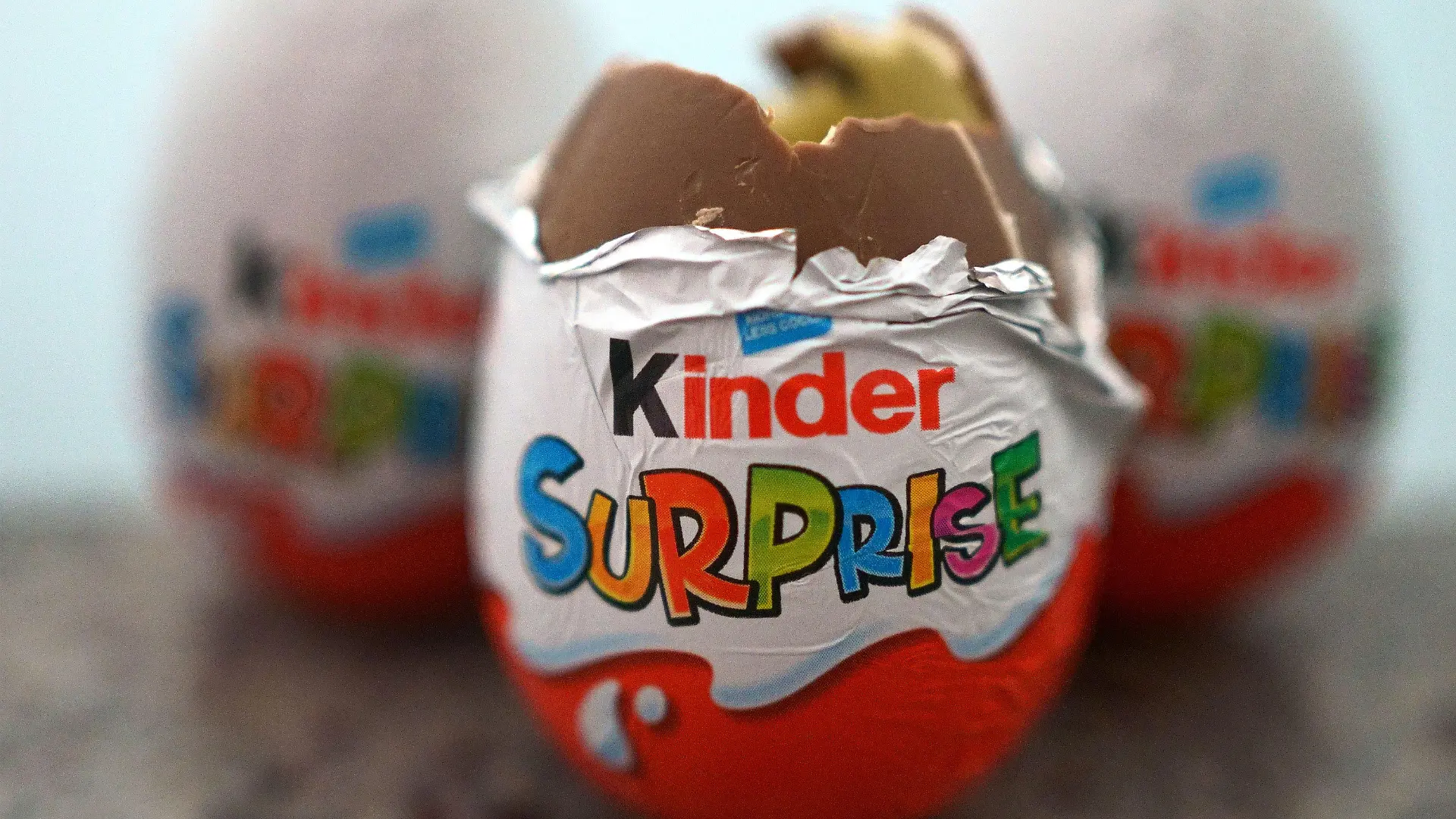 04.04.2022, Großbritannien, London: Drei britische Varianten der Kinder-Überraschungseier liegen auf einem Tisch. Wegen mehr als 60 Fällen von Salmonellen-Erkrankungen in Großbritannien hat Ferrero knapp zwei Wochen vor Ostern einige Chargen an Kinder-Überraschungseiern zurückgerufen. Foto: Victoria Jones/PA Wire/dpa +++ dpa-Bildfunk +++