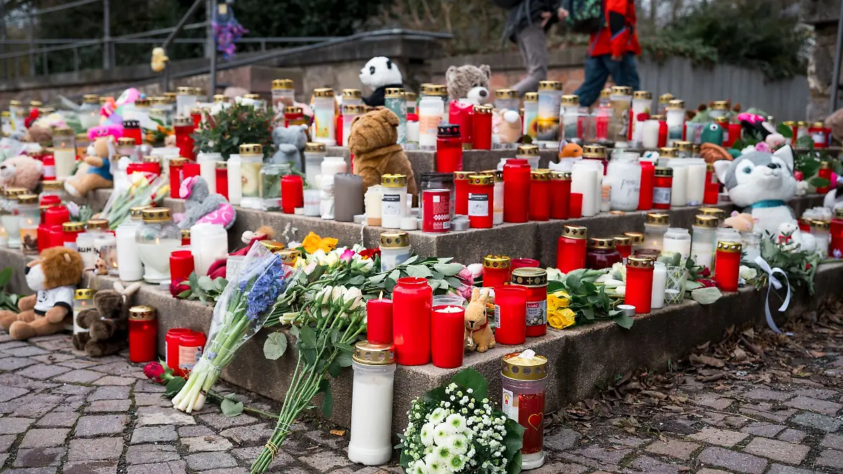 Viele Menschen kommen zum Tatort und legen Blumen und Kerzen ab.