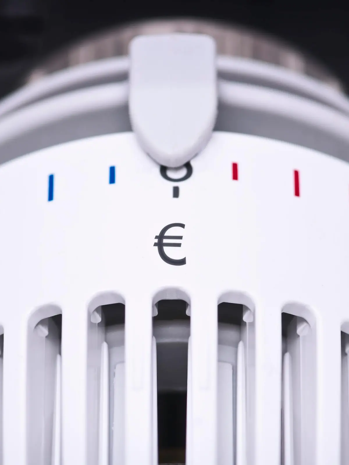 Close up of Thermostat of an heating radiator with Euro symbol, rising costs for heat and energy concept.