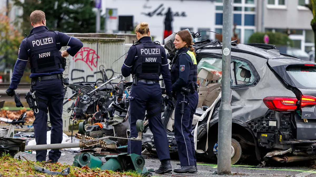 Polizeibeamte stehen am verunfallten Wrack des BMW X5 in Düsseldorf-Golzheim