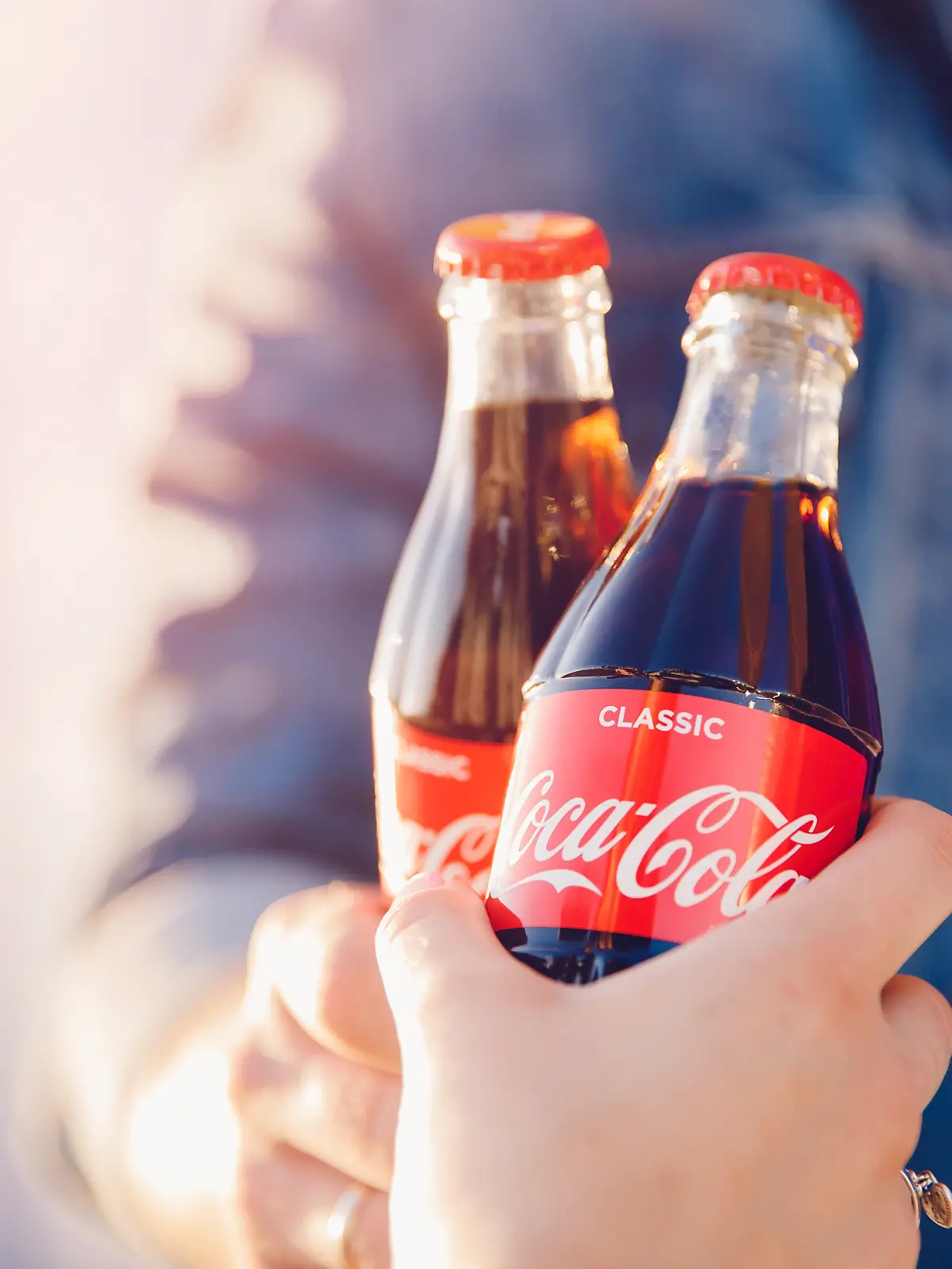 Zwei Personen stoßen mit Coca Cola an