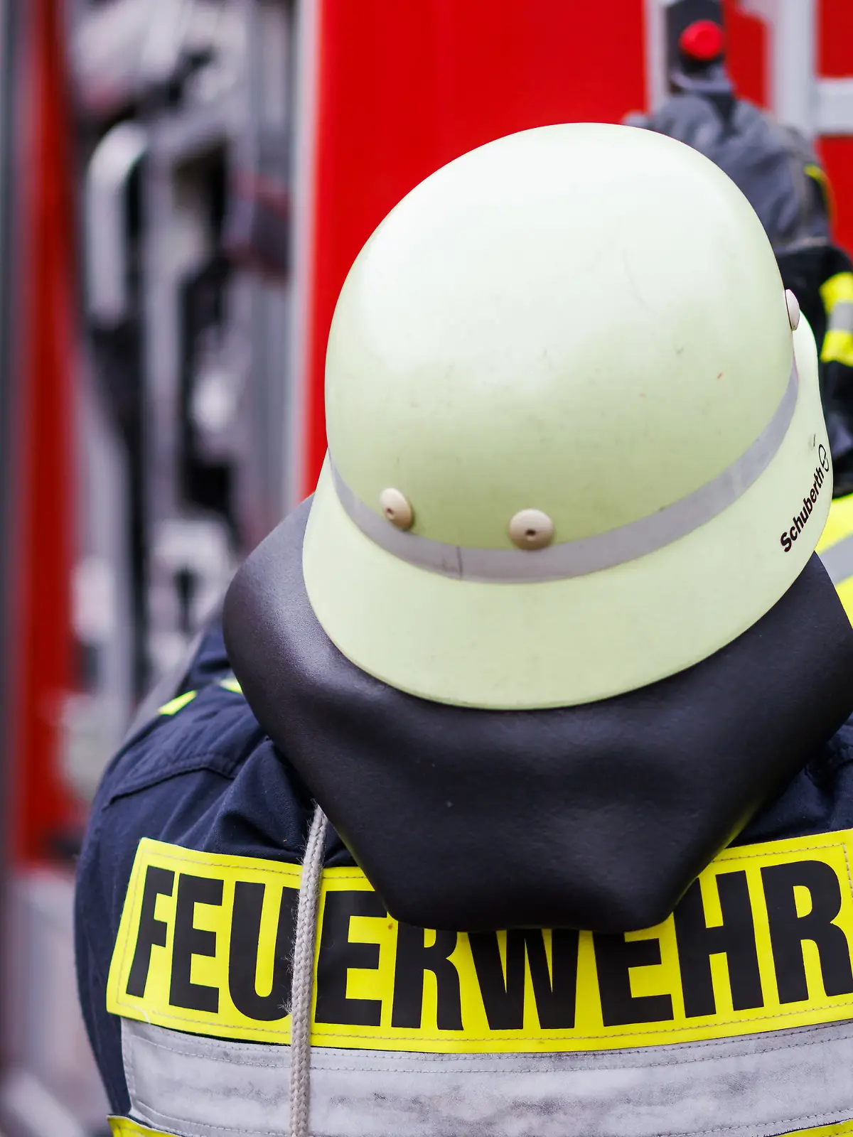 Ein Feuerwehrmann holt während einer Einsatzübung einer Freiwilligen Feuerwehr eine Leiter vom Dach eines Einsatzfahrzeugs. 