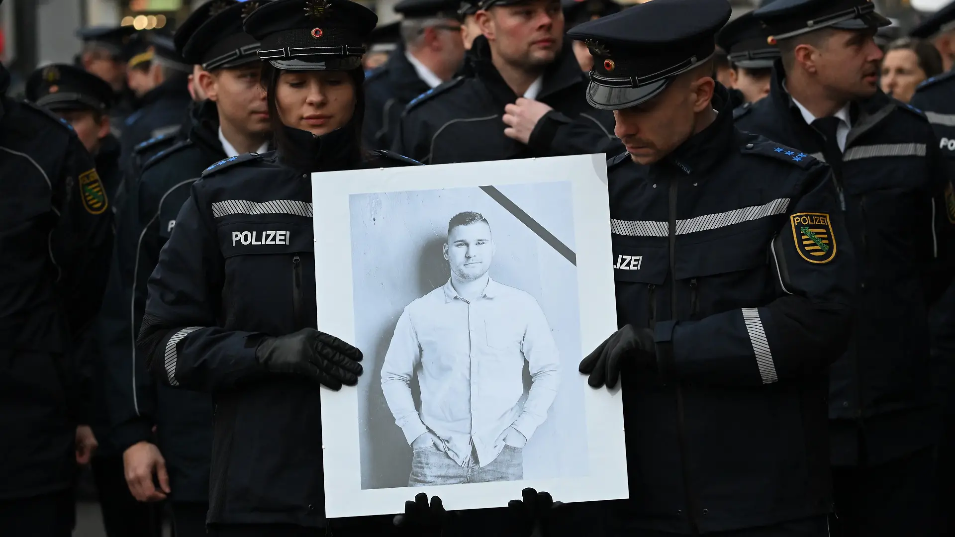 Polizisten tragen während eines Trauermarschs der sächsischen Polizei für den vor drei Wochen im Dienst getöteten Polizisten Maximilian Stoppa ein Porträt.