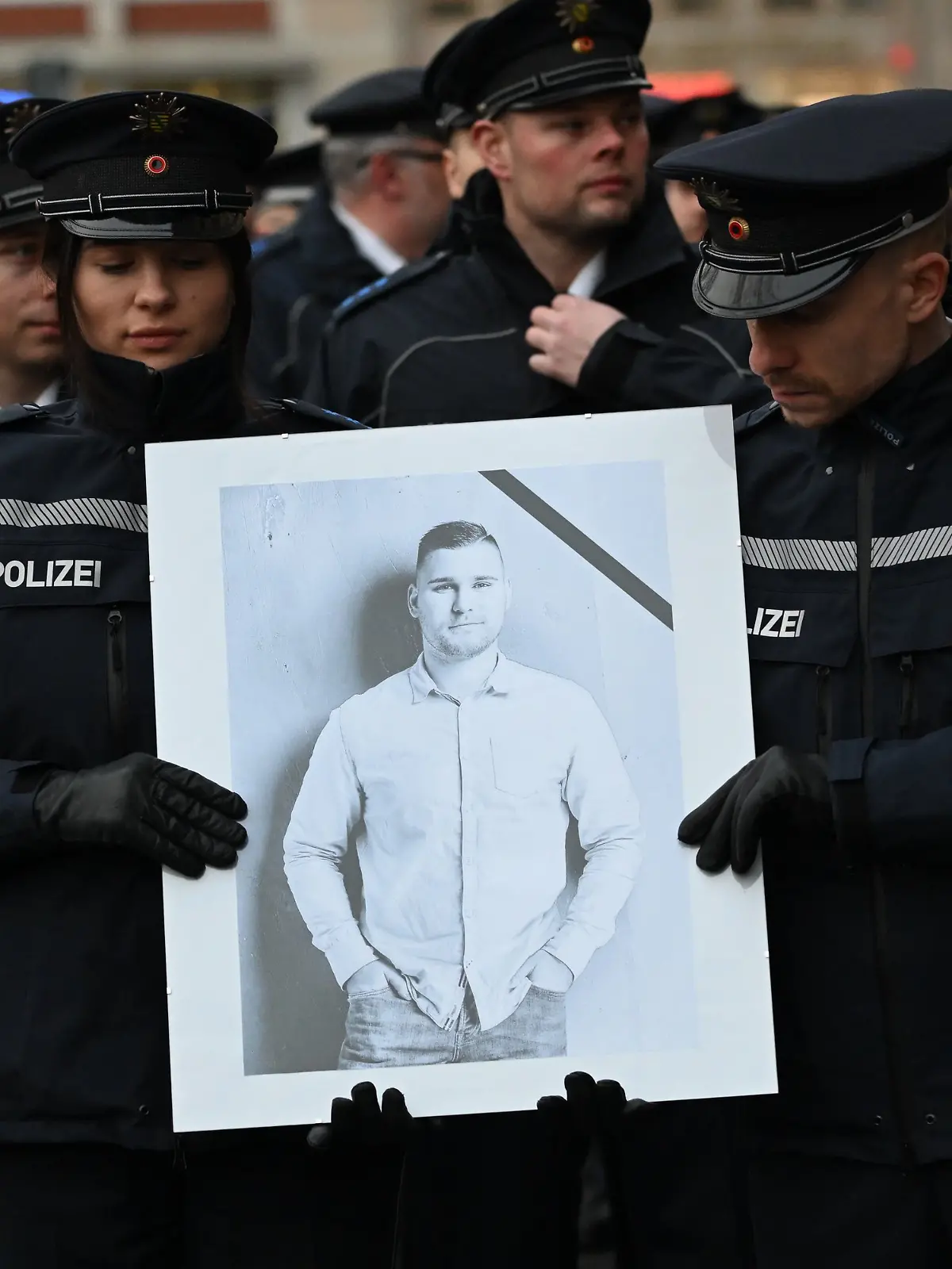 Polizisten tragen während eines Trauermarschs der sächsischen Polizei für den vor drei Wochen im Dienst getöteten Polizisten Maximilian Stoppa ein Porträt. 