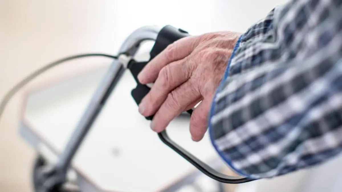 Ein älterer Mann geht mit einem Rollator