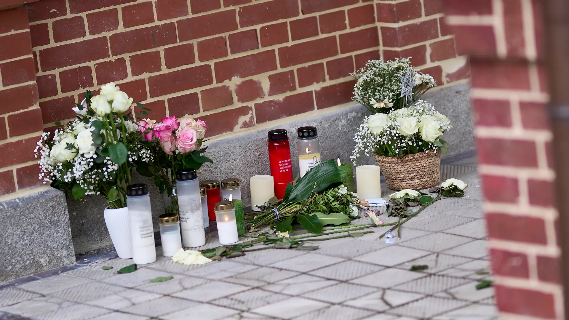 28.01.2025, Brandenburg, Beelitz: Blumen und Kerzen stehen vor dem Eingang eines Hauses nach einem Gewaltverbrechen. Nach dem Tod eines 24-Jährigen Mannes ist eine Person festgenommen worden. Nach zwei Gewaltverbrechen in Beelitz ermittelt die Staatsanwaltschaft gegen einen Verdächtigen wegen des Vorwurfes des Mordes und des versuchten Mordes. Foto: Michael Ukas/dpa +++ dpa-Bildfunk +++ 