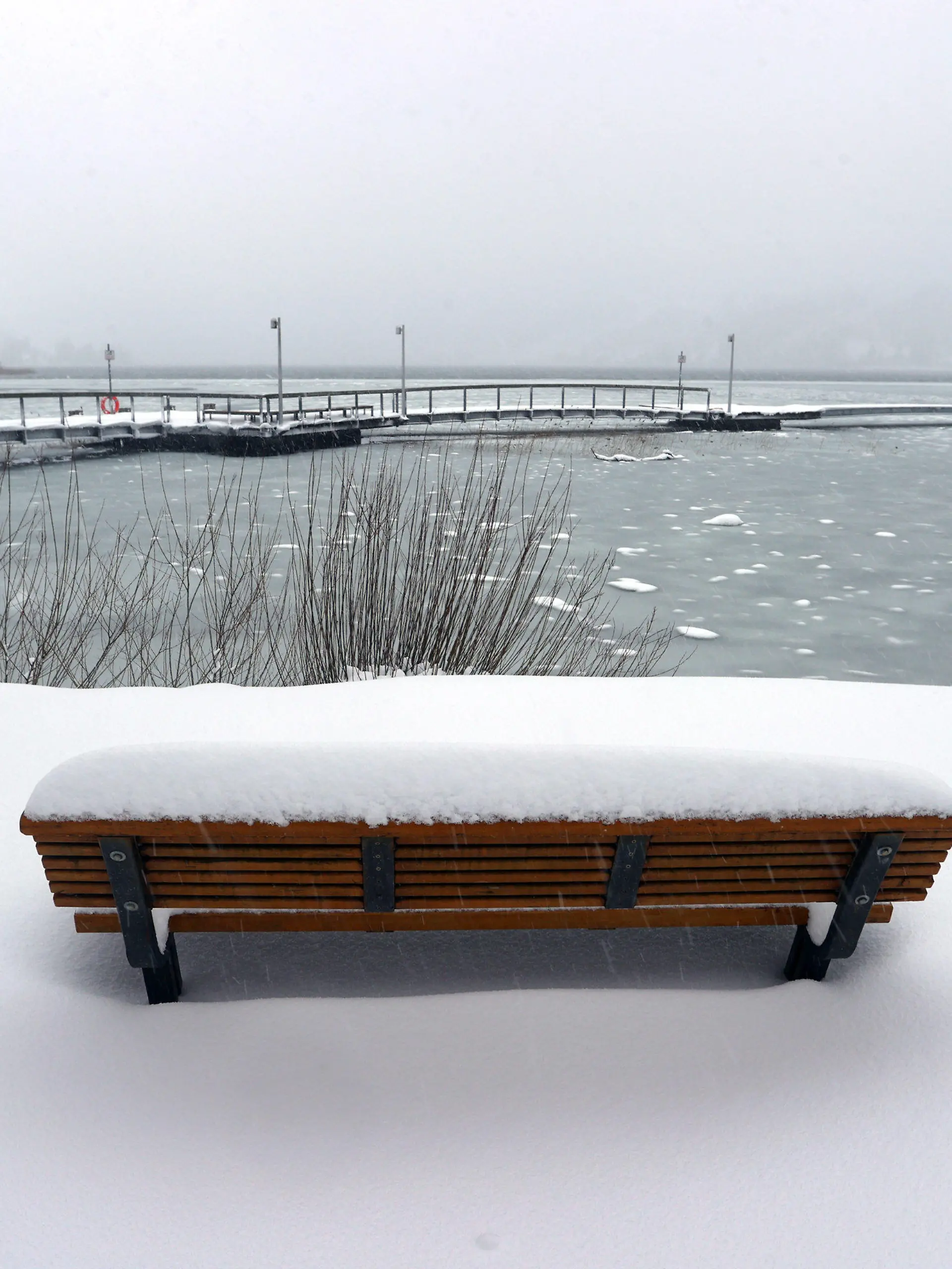 ARCHIV - 01.02.2022, Bayern, Blaichach: Eine schneebedeckte Sitzbank steht am Ufer des großen Alpsees. (zu dpa: «Großeinsatz am Alpsee: Helfer holen rund 60 Leute vom Eis») Foto: Karl-Josef Hildenbrand/dpa +++ dpa-Bildfunk +++