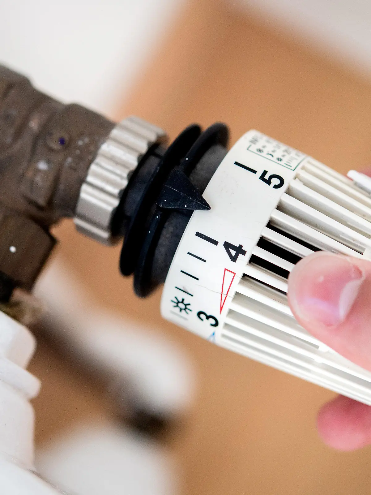 ARCHIV - 04.10.2021, Niedersachsen, Hannover: ILLUSTRATION - Ein Mann dreht in einer Wohnung am Thermostat einer Heizung. (zu dpa: «Mieter sollen Klimaabgabe beim Heizen nicht mehr alleine zahlen») Foto: Hauke-Christian Dittrich/dpa +++ dpa-Bildfunk +++