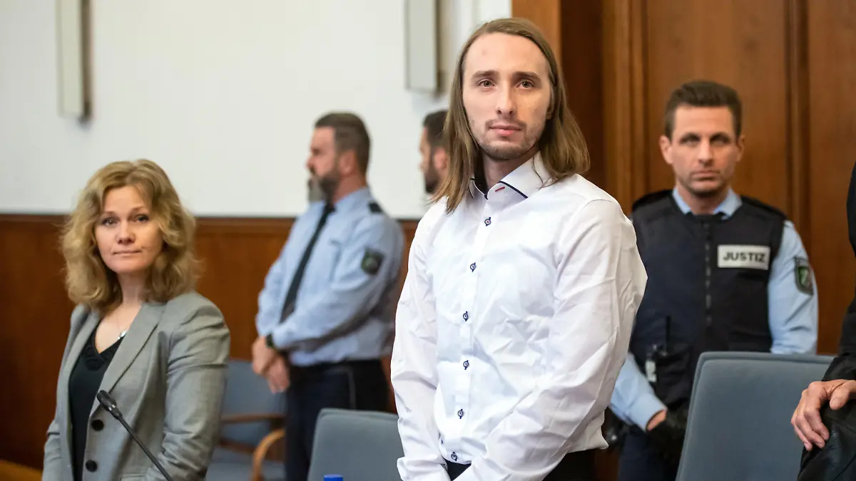 ARCHIV - 22.11.2018, Nordrhein-Westfalen, Dortmund: Der Angeklagte Sergej W. steht im Gerichtssaal des Landgerichts neben einer Dolmetscherin. Seit elf Monaten verhandelt das Dortmunder Schwurgericht den Bombenanschlag auf die Mannschaft von Borussia Dortmund. Foto: Bernd Thissen/dpa +++ dpa-Bildfunk +++