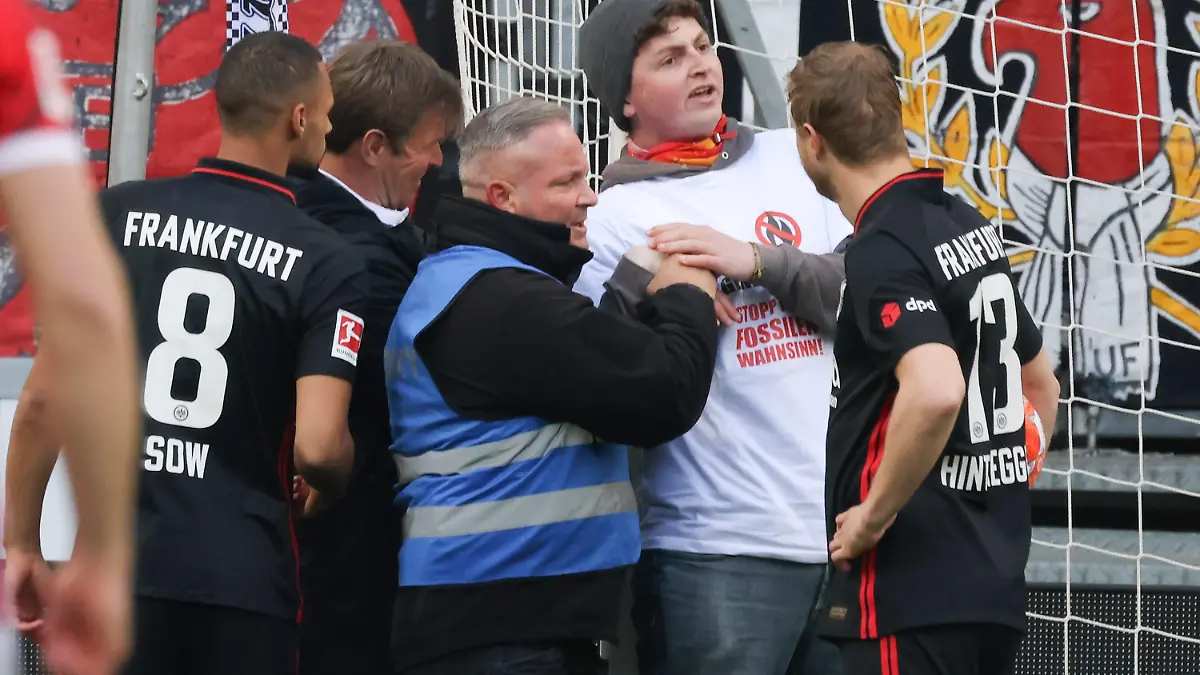  Eintracht Frankfurt - SC Freiburg, 1. FBL Umweltaktivist am Torpfosten. Djibril Sow Eintracht Frankfurt, 8 und Martin Hinteregger Eintracht Frankfurt, 13. Bundesligaspiel zwischen Eintracht Frankfurt und dem SC Freiburg am 10. April 2022 im Deutsche Bank Park in Frankfurt am Main. Nach Vorgaben der DFL, Deutsche Fußball Liga, ist es untersagt, in dem Stadion und/oder vom Spiel angefertigte Fotoaufnahmen in Form von Sequenzbildern und/oder videoähnlichen Fotostrecken zu verwerten bzw. verwerten zu lassen., Frankfurt am Main Hessen Deutschland Deutsche Bank Park *** Eintracht Frankfurt SC Freiburg, 1 FBL environmental activist at the goal post Djibril Sow Eintracht Frankfurt, 8 and Martin Hinteregger Eintracht Frankfurt, 13 Bundesliga match between Eintracht Frankfurt and SC Freiburg on 10 April 2022 at Deutsche Bank Park in Frankfurt am Main According to the requirements of the DFL, German Football League, it is prohibited in the stadium and or from the game made photographs in the form of sequence pictures and or video-like photo series to exploit or to let exploit , Frankfurt am Main Hesse Germany Deutsche Bank Park