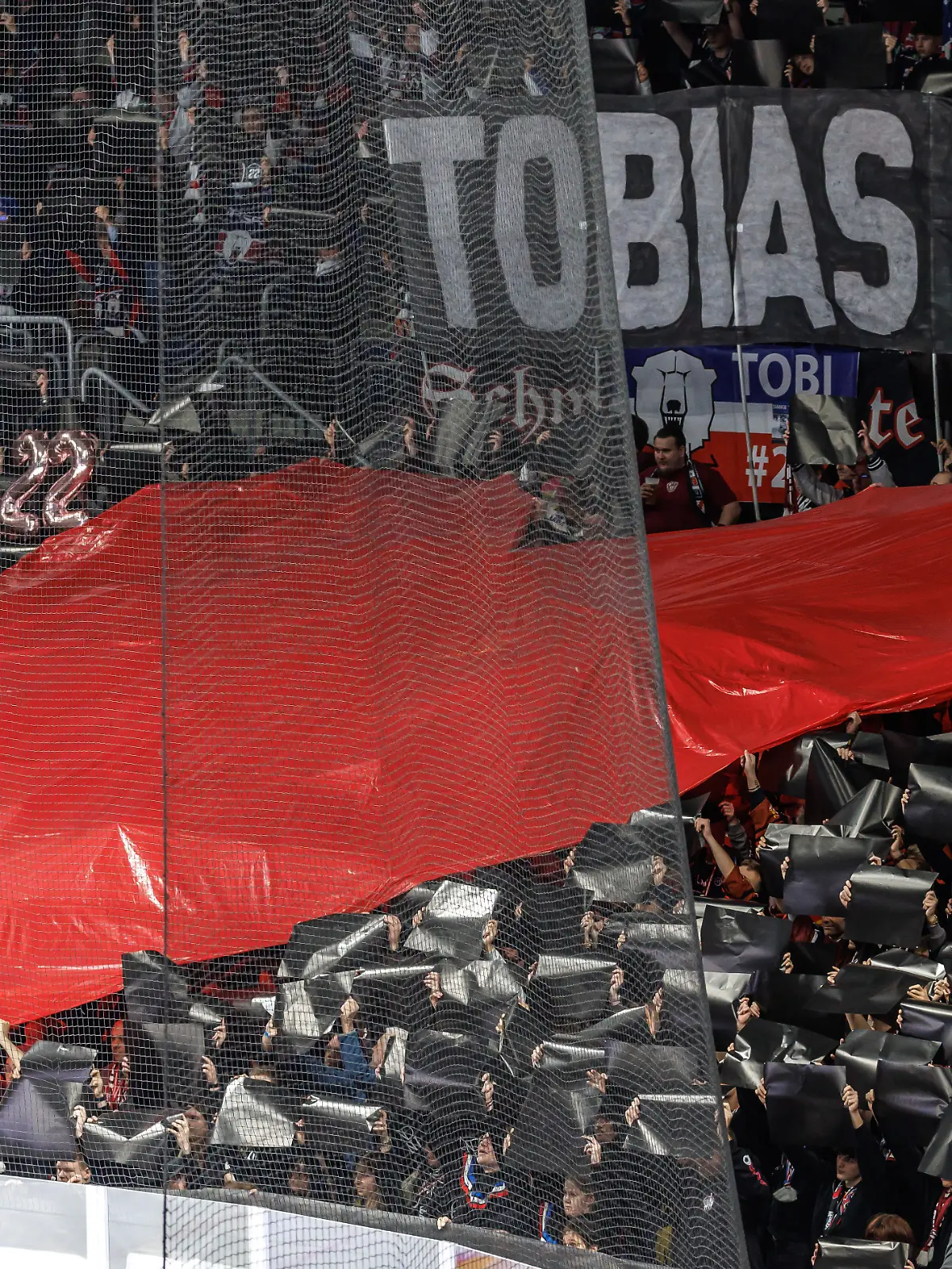 Fans der Berliner Eisbären halten ein großes Herz zu Ehren an Tobias Eder in die Höhe.