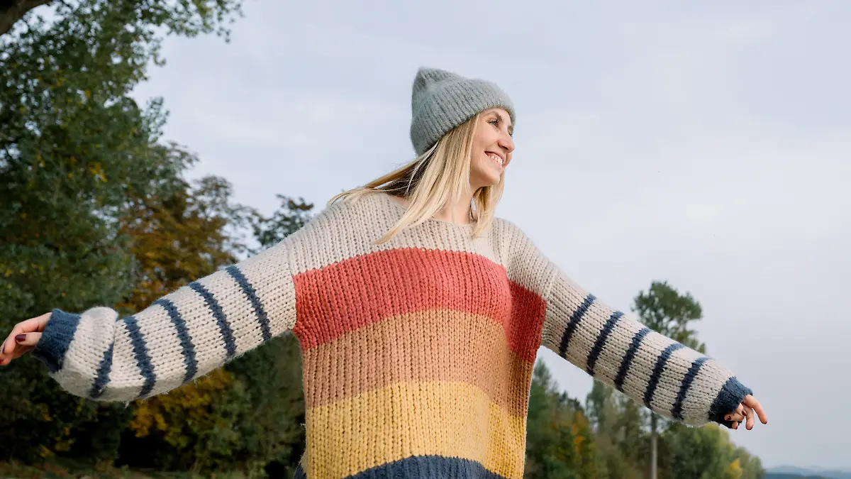 Frau mit buntem Strickpullover.