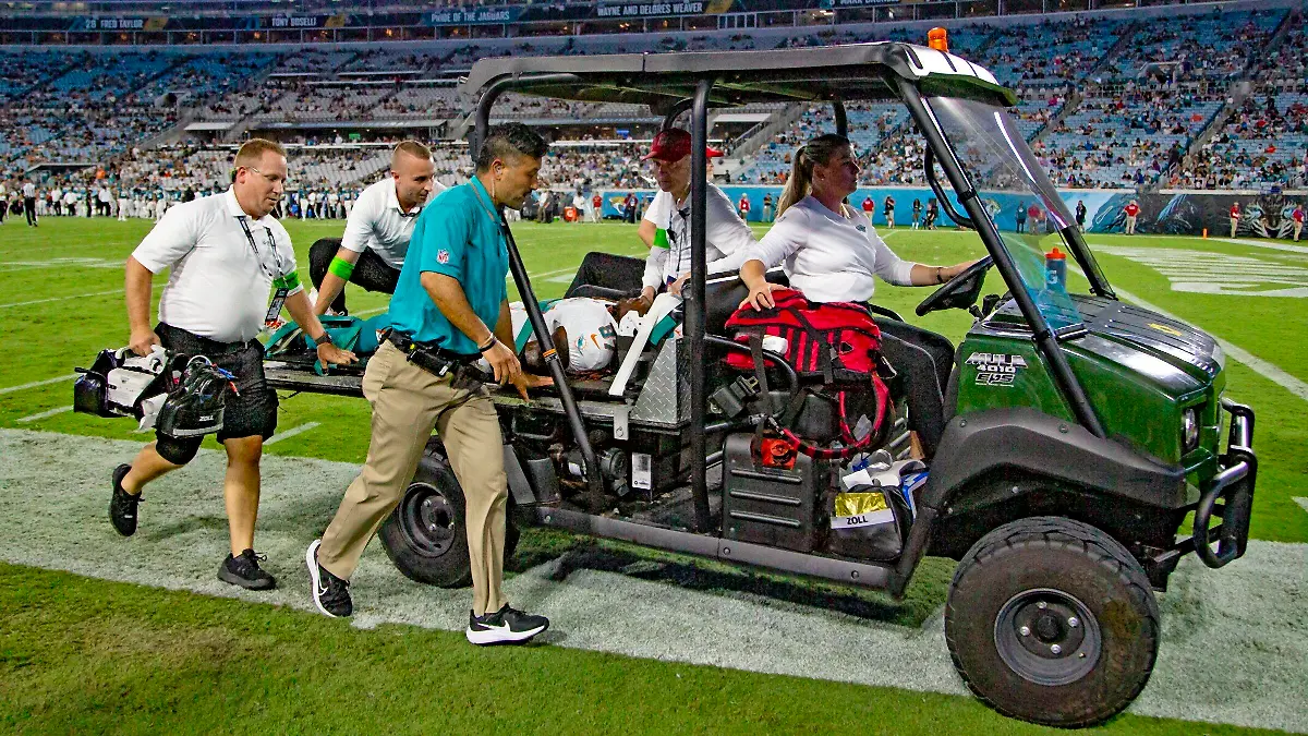 26.08.2023, USA, Jacksonville: American Football: Profiliga NFL, Vorsaison, Jacksonville Jaguars - Miami Dolphins. Wide Receiver Daewood Davis (87) von den Miami Dolphins wird während des Vorbereitungsspiels vom Spielfeld getragen. In der NFL ist knapp zwei Wochen vor dem Saisonstart erneut ein Testspiel nach der Verletzung eines Football-Profis abgebrochen worden. Daewood Davis von den Miami Dolphins blieb nach einem harten Zusammenprall in der Partie gegen die Jacksonville Jaguars am Samstag (Ortszeit) minutenlang mit dem Gesicht auf dem Boden liegen. Foto: Al Diaz/Miami Herald/AP/dpa - ACHTUNG: Nur zur redaktionellen Verwendung und nur mit vollständiger Nennung des vorstehenden Credits +++ dpa-Bildfunk +++