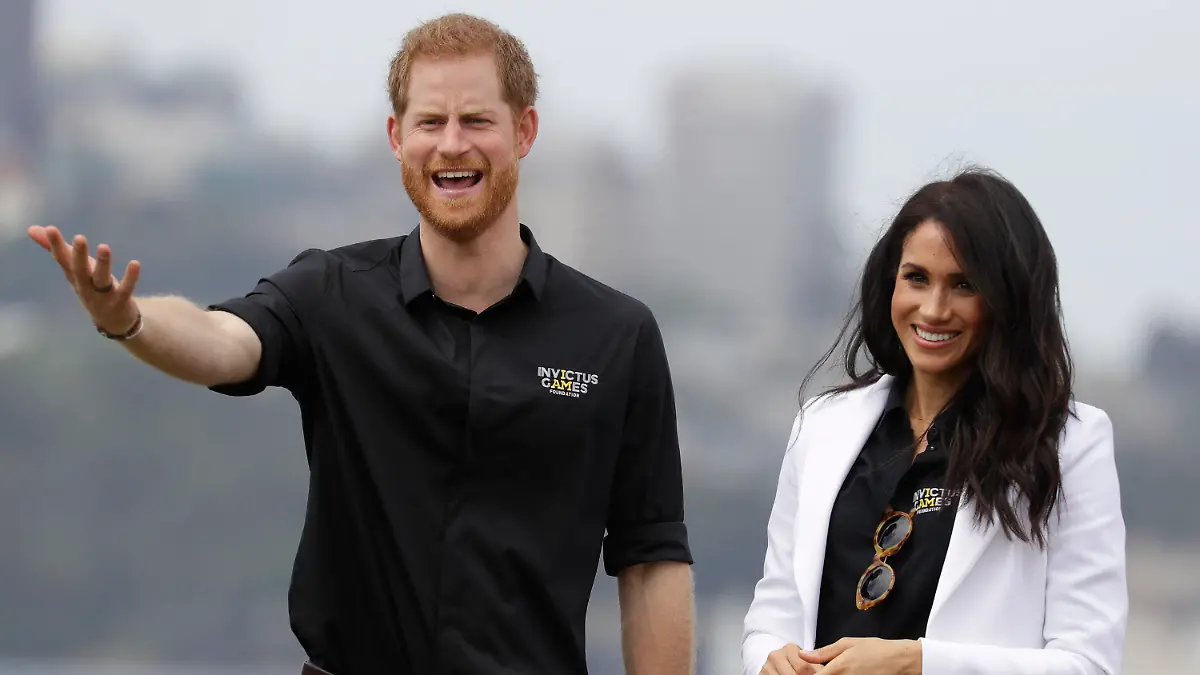 ARCHIV - 20.10.2018, Australien, Sydney: Prinz Harry von Großbritannien gestikuliert neben seiner Ehefrau Herzogin Meghan bei den Invictus Games auf der Cockatoo Island. (zu dpa: «Meghan will Prinz Harry zu den Invictus Games nach Europa begleiten») Foto: Kirsty Wigglesworth/AP/dpa +++ dpa-Bildfunk +++