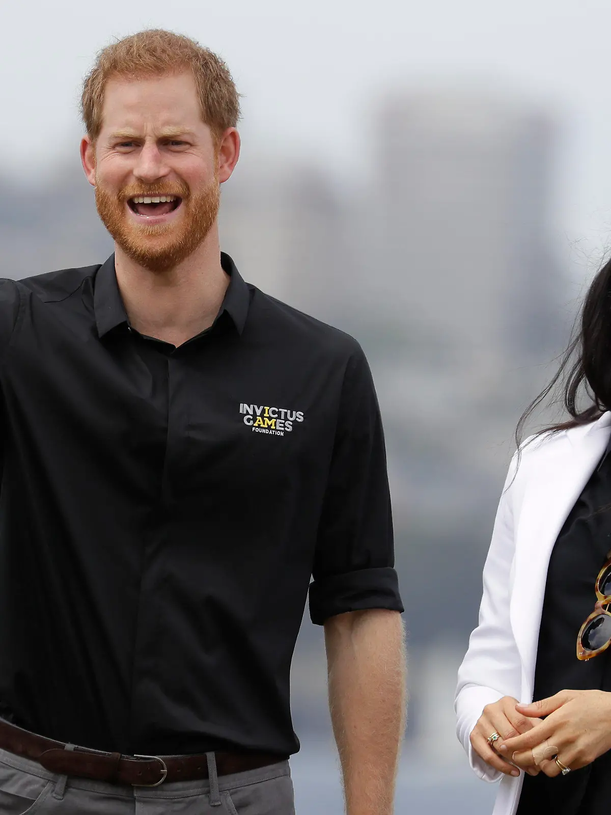 ARCHIV - 20.10.2018, Australien, Sydney: Prinz Harry von Großbritannien gestikuliert neben seiner Ehefrau Herzogin Meghan bei den Invictus Games auf der Cockatoo Island. (zu dpa: «Meghan will Prinz Harry zu den Invictus Games nach Europa begleiten») Foto: Kirsty Wigglesworth/AP/dpa +++ dpa-Bildfunk +++