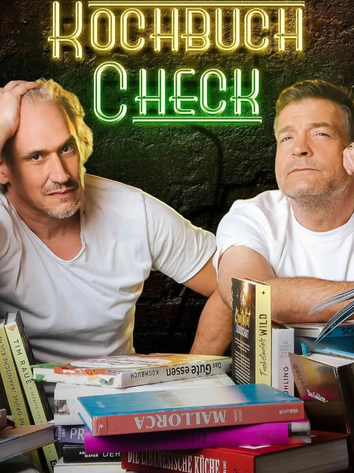 Zwei Mäneer vor einem Haufen an Kochbüchern