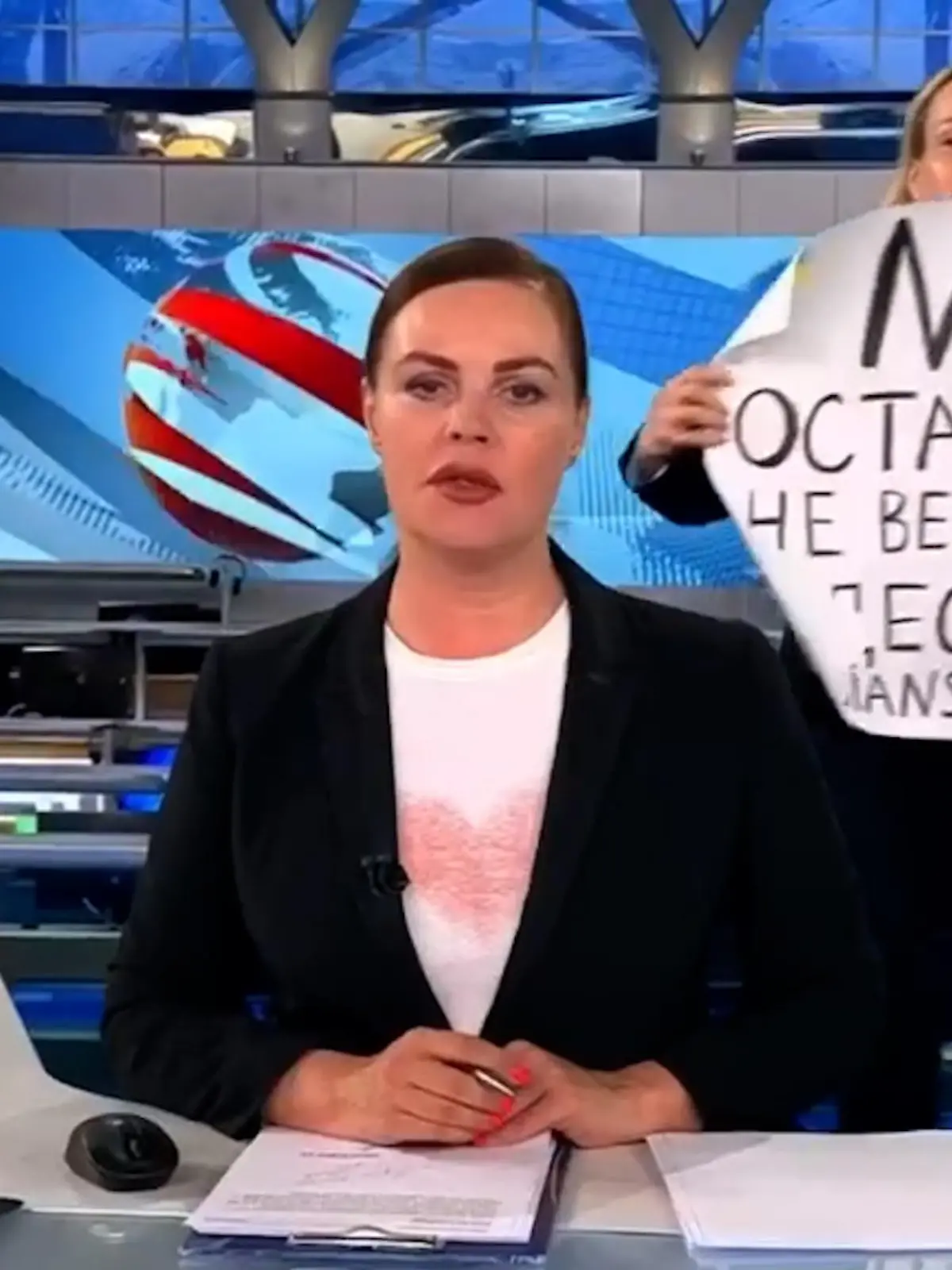 ARCHIV - 14.03.2022, Russland, ---: Der Screenshot aus der abendlichen Hauptnachrichtensendung des russischen Staatsfernsehen zeigt die Protestaktion von Marina Owssjannikowa. Während der Live-Übertragung am Montag 14.03.2022 um 21.00 Uhr Moskauer Zeit (19.00 Uhr MEZ) sprang Ovsyannikova plötzlich hinter Nachrichtensprecherin Jekaterina Andrejewa ins Bild und hielt ein Schild mit der Aufschrift «Stoppt den Krieg. Glaubt der Propaganda nicht. Hier werdet ihr belogen» hoch. (zum dpa Korr "Die Gesichter des ersten Monats Krieg") Foto: ---/Social Media/dpa - ACHTUNG: Nur zur redaktionellen Verwendung im Zusammenhang mit der aktuellen Berichterstattung über ihre Aktion. // Bestmögliche Qualität +++ dpa-Bildfunk +++