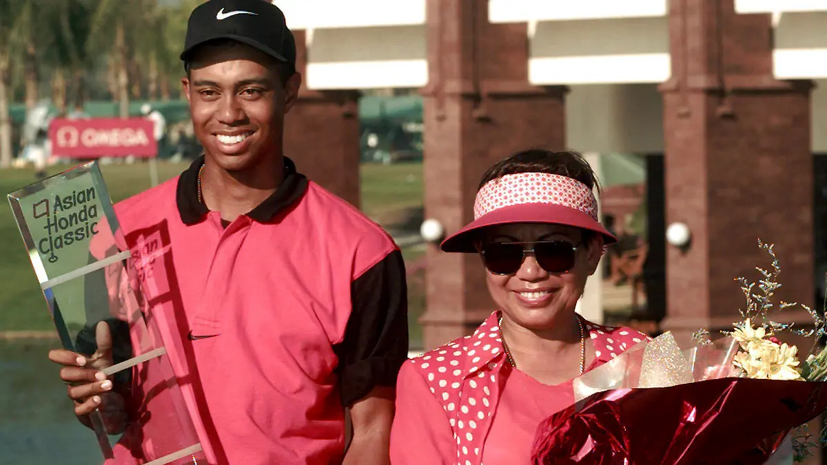 FILE - Golf sensation Tiger Woods, left, poses with his mother Kultida while holding his trophy and key to a new car after winning the Asian Honda Classic in Bangkok, Thailand, Sunday, Feb. 9, 1997. (AP Photo/Charles Dharapak, File)