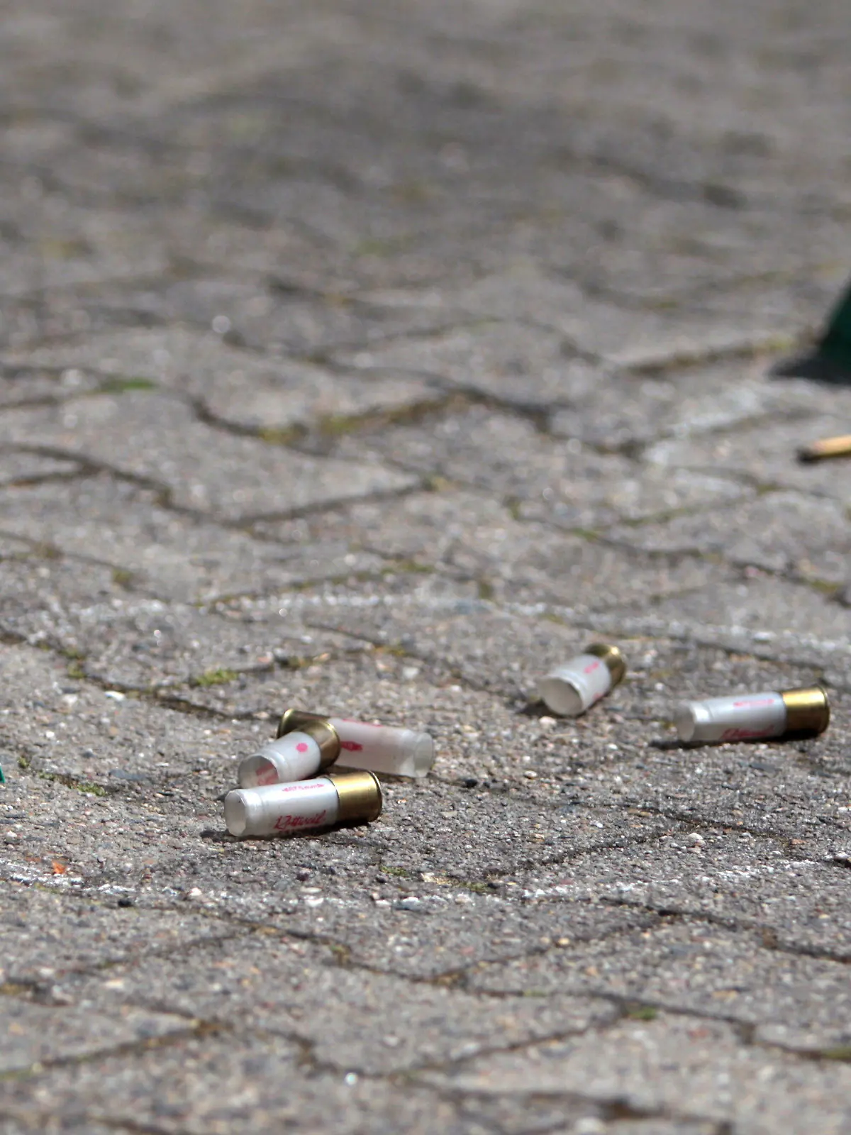 An der Stelle, an der zuvor ein Mann erschossen worden ist, liegen am 17.05.2015 am Tatort in Rodgau (Hessen) Polizei-Markierungen an Patronenhülsen und Einschusslöchern. Bei einem Polizeieinsatz in Rodgau (Kreis Offenbach) ist am Sonntagmorgen ein 74-Jähriger getötet worden. Laut dem Landeskriminalamt (LKA) Wiesbaden habe der Mann zuvor auf die Einsatzkräfte geschossen, um seine Einweisung in eine Klinik zu verhindern. Mehrere Beamte eines Spezialeinsatzkommandos (SEK) schossen zurück und verletzten den Mann tödlich. Foto: Fredrik von Erichsen/dpa +++(c) dpa - Bildfunk+++
