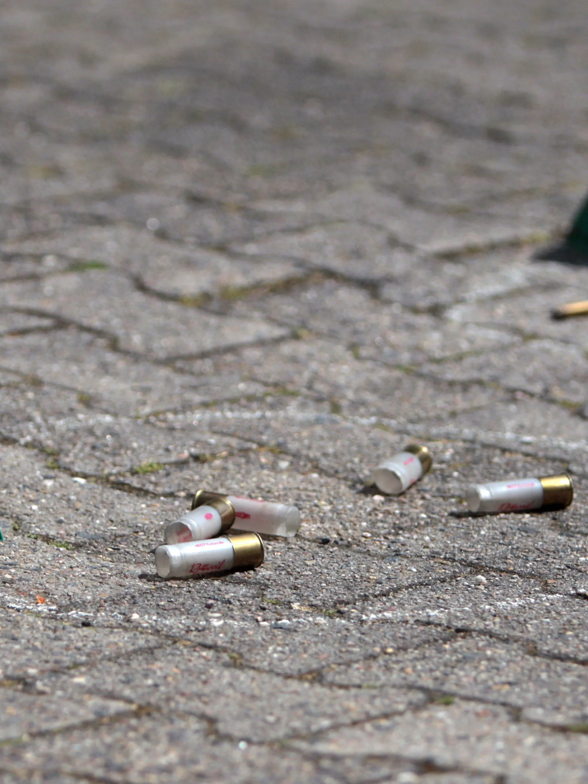 An der Stelle, an der zuvor ein Mann erschossen worden ist, liegen am 17.05.2015 am Tatort in Rodgau (Hessen) Polizei-Markierungen an Patronenhülsen und Einschusslöchern. Bei einem Polizeieinsatz in Rodgau (Kreis Offenbach) ist am Sonntagmorgen ein 74-Jähriger getötet worden. Laut dem Landeskriminalamt (LKA) Wiesbaden habe der Mann zuvor auf die Einsatzkräfte geschossen, um seine Einweisung in eine Klinik zu verhindern. Mehrere Beamte eines Spezialeinsatzkommandos (SEK) schossen zurück und verletzten den Mann tödlich. Foto: Fredrik von Erichsen/dpa +++(c) dpa - Bildfunk+++