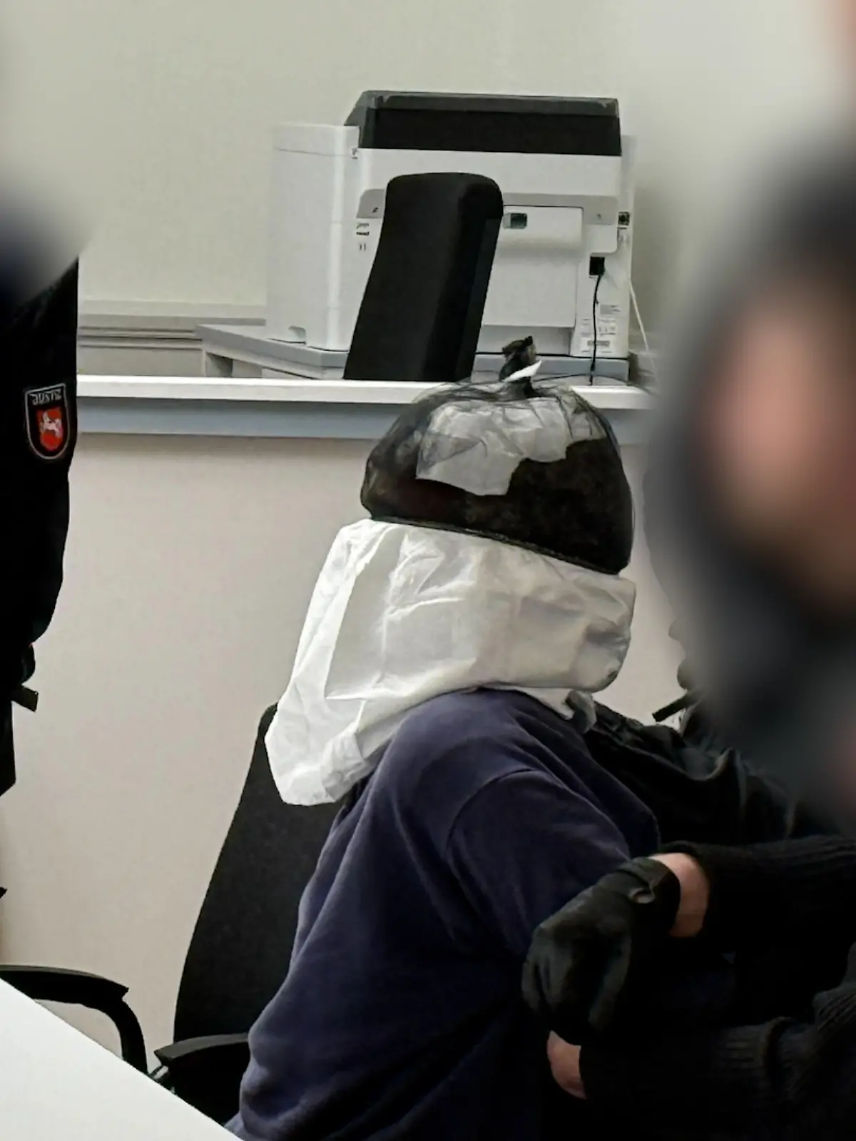 Mit einem Spuckschutz sitzt der 30-Jährigen aus Guinea-Bissau vor Gericht.