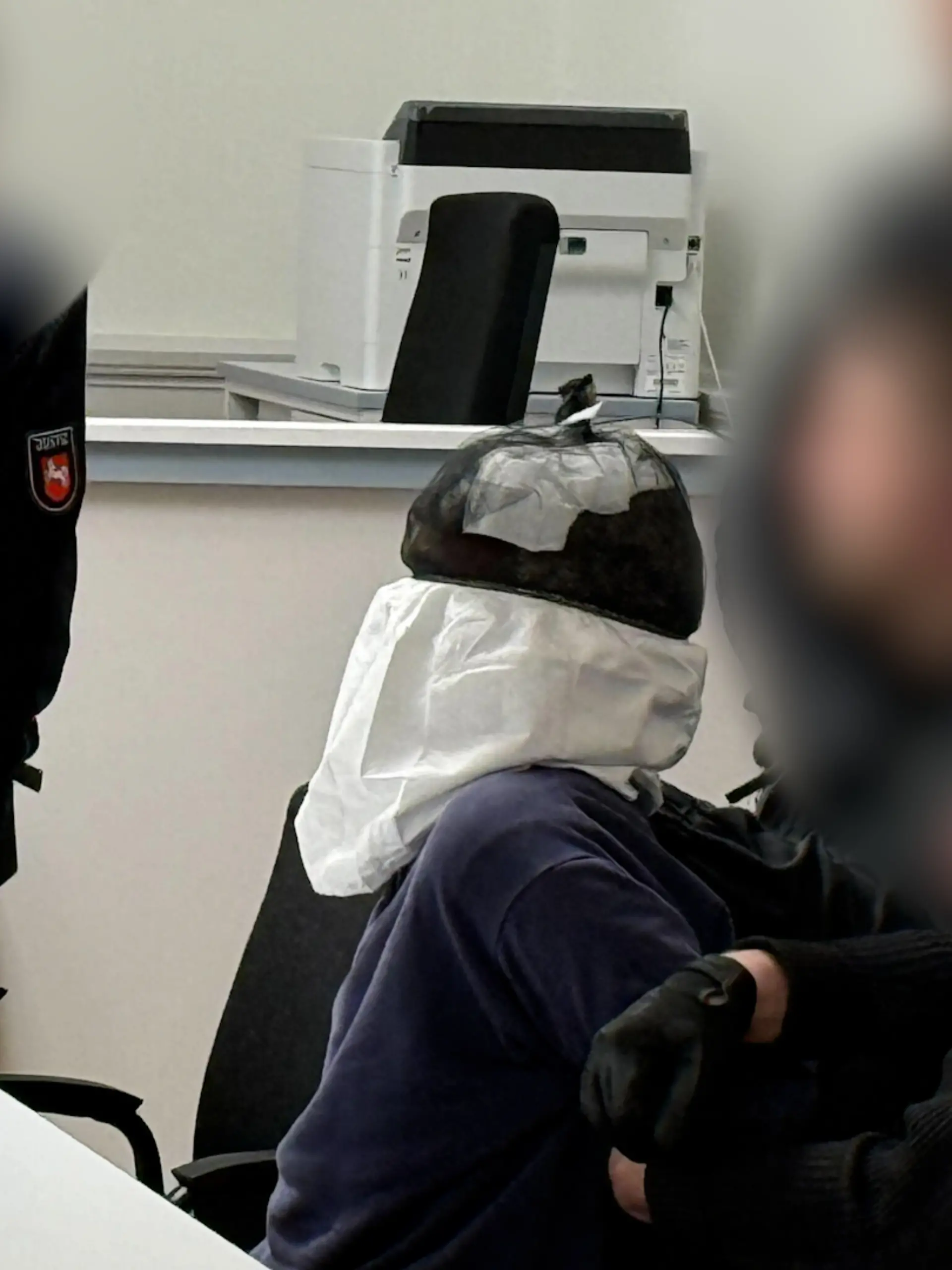 Mit einem Spuckschutz sitzt der 30-Jährigen aus Guinea-Bissau vor Gericht.