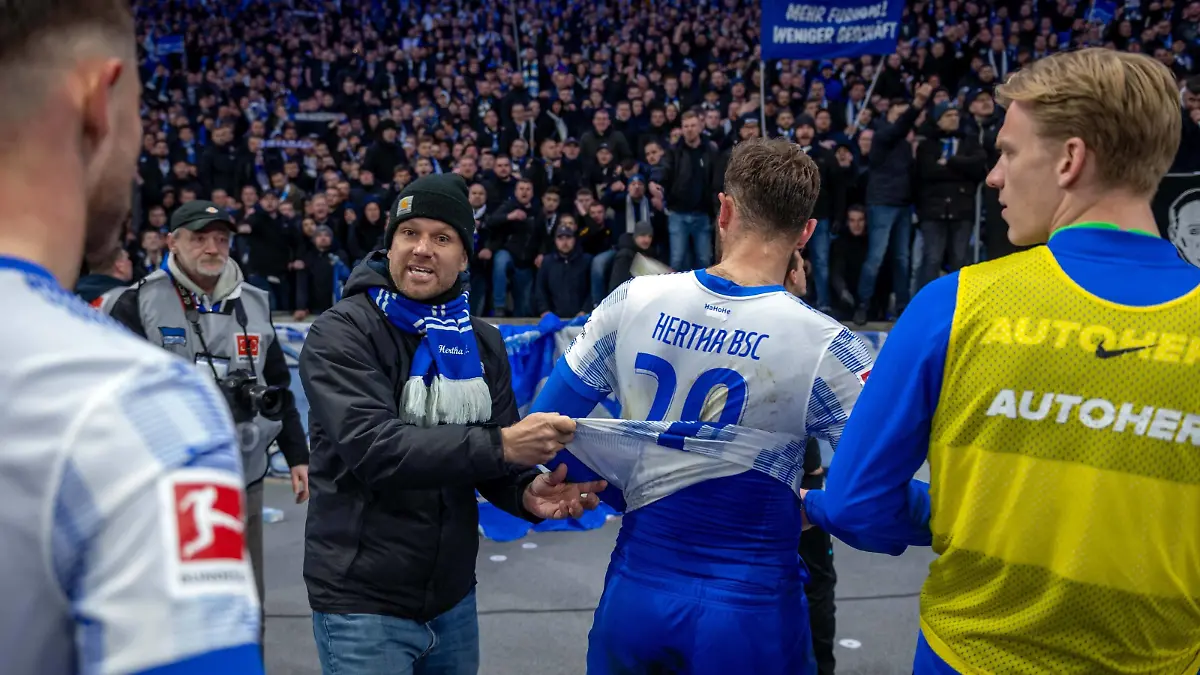 Fussball Berlin 09.04.2022 Saison 2021 / 2022 1. Bundesliga / DFL Hertha BSC Berlin - 1. FC Union Berlin niedergeschlagene Herthaspieler nach der 1:4 Niederlage enttäuscht Lucas Tousart Hertha BSC, No.29 vor der Hertha Fankurve Ostkurve Ein Hertha Fan will, dass die Spieler ihr Trikot symbolisch ausziehen Hertha Fans *** Football Berlin 09 04 2022 Season 2021 2022 1 Bundesliga DFL Hertha BSC Berlin 1 FC Union Berlin dejected Hertha players disappointed after the 1 4 defeat Lucas Tousart Hertha BSC, No 29 in front of the Hertha Fankurve Ostkurve A Hertha fan wants the players to take off their jersey symbolically Hertha fans 