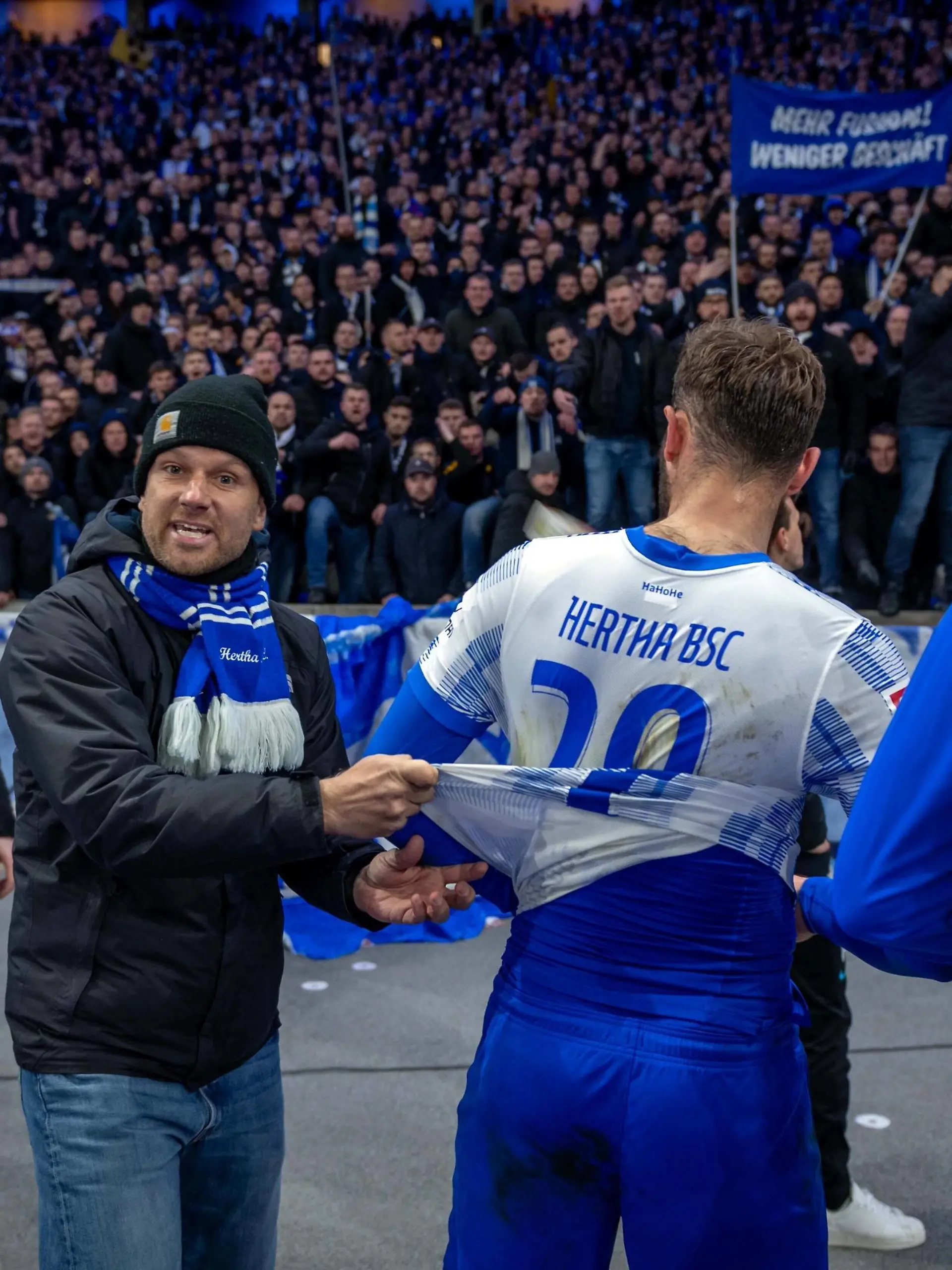 Fussball Berlin 09.04.2022 Saison 2021 / 2022 1. Bundesliga / DFL Hertha BSC Berlin - 1. FC Union Berlin niedergeschlagene Herthaspieler nach der 1:4 Niederlage enttäuscht Lucas Tousart Hertha BSC, No.29 vor der Hertha Fankurve Ostkurve Ein Hertha Fan will, dass die Spieler ihr Trikot symbolisch ausziehen Hertha Fans *** Football Berlin 09 04 2022 Season 2021 2022 1 Bundesliga DFL Hertha BSC Berlin 1 FC Union Berlin dejected Hertha players disappointed after the 1 4 defeat Lucas Tousart Hertha BSC, No 29 in front of the Hertha Fankurve Ostkurve A Hertha fan wants the players to take off their jersey symbolically Hertha fans 