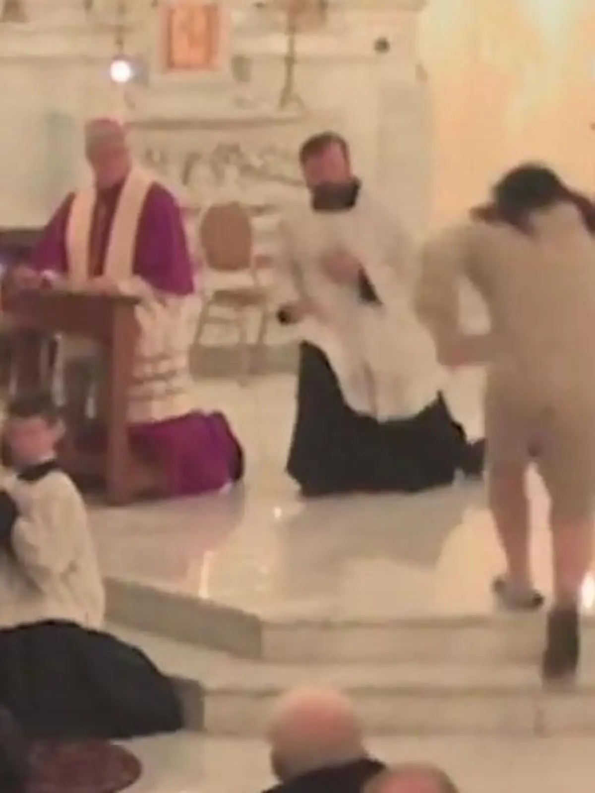 Mann schlägt auf Priester ein.