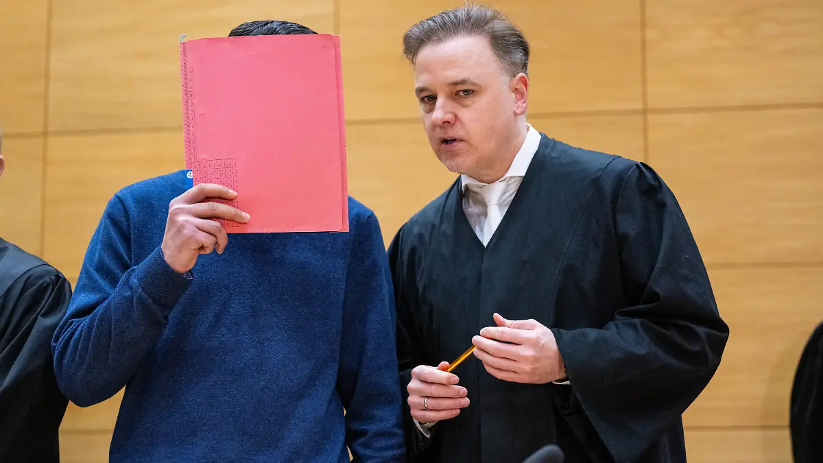 Einer der Angeklagten (l.) steht mit seinem Anwalt Burkhard Benecken beim Beginn des Prozesses um den Totschlag nach einer Abifeier in Bad Oeynhausen vor dem Landgericht. Angeklagt sind drei Männer. (zu dpa: «Aussage angekündigt: Prozess um Tod nach Abifeier in Bad Oeynhausen») Foto: Guido Kirchner/dpa +++ dpa-Bildfunk +++